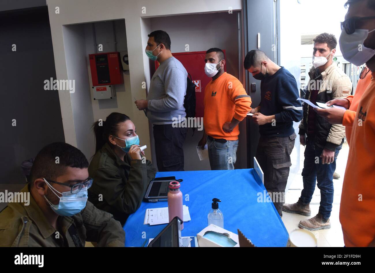 Les travailleurs palestiniens attendent en ligne pour recevoir la première dose du vaccin Moderna COVID-19 au point de contrôle de Lamed Hei entre Gush Etzion et Beit Shemesh, le lundi 8 mars 2021. Israël a lancé une campagne de deux semaines pour vacciner quelque 100,000 travailleurs palestiniens de Cisjordanie qui détiennent des permis de travail en Israël et dans les colonies juives. La campagne de vaccination est un projet conjoint du Ministère israélien de la santé, du Ministère de la défense, de l'Autorité de passage des terres et de la coordination des activités gouvernementales dans les territoires. Photo par Debbie Hill/UPI Banque D'Images