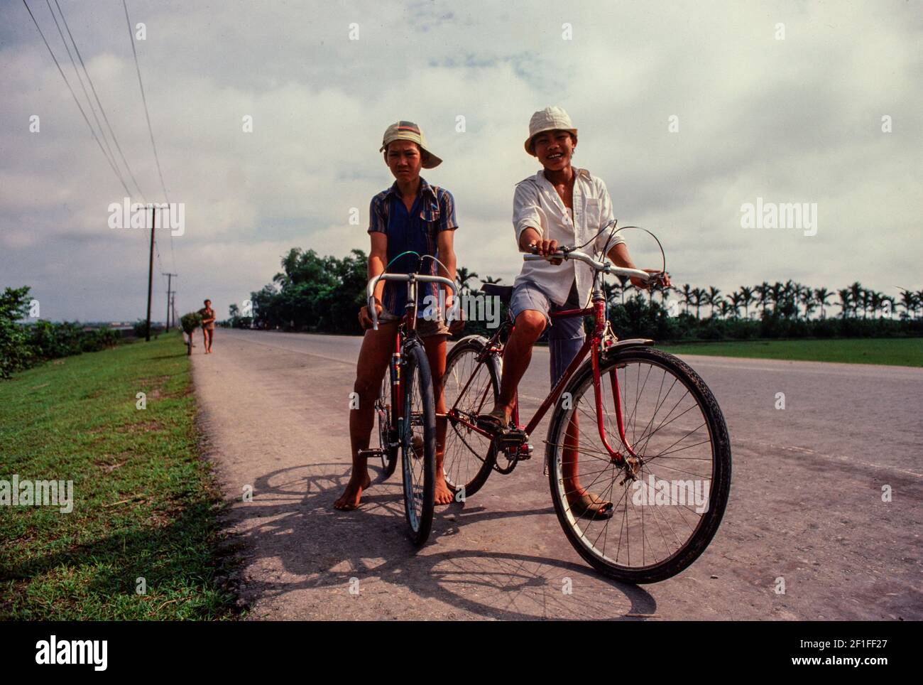 Les garçons sur leurs vélos, rural Sud Vietnam, juin 1980 Banque D'Images