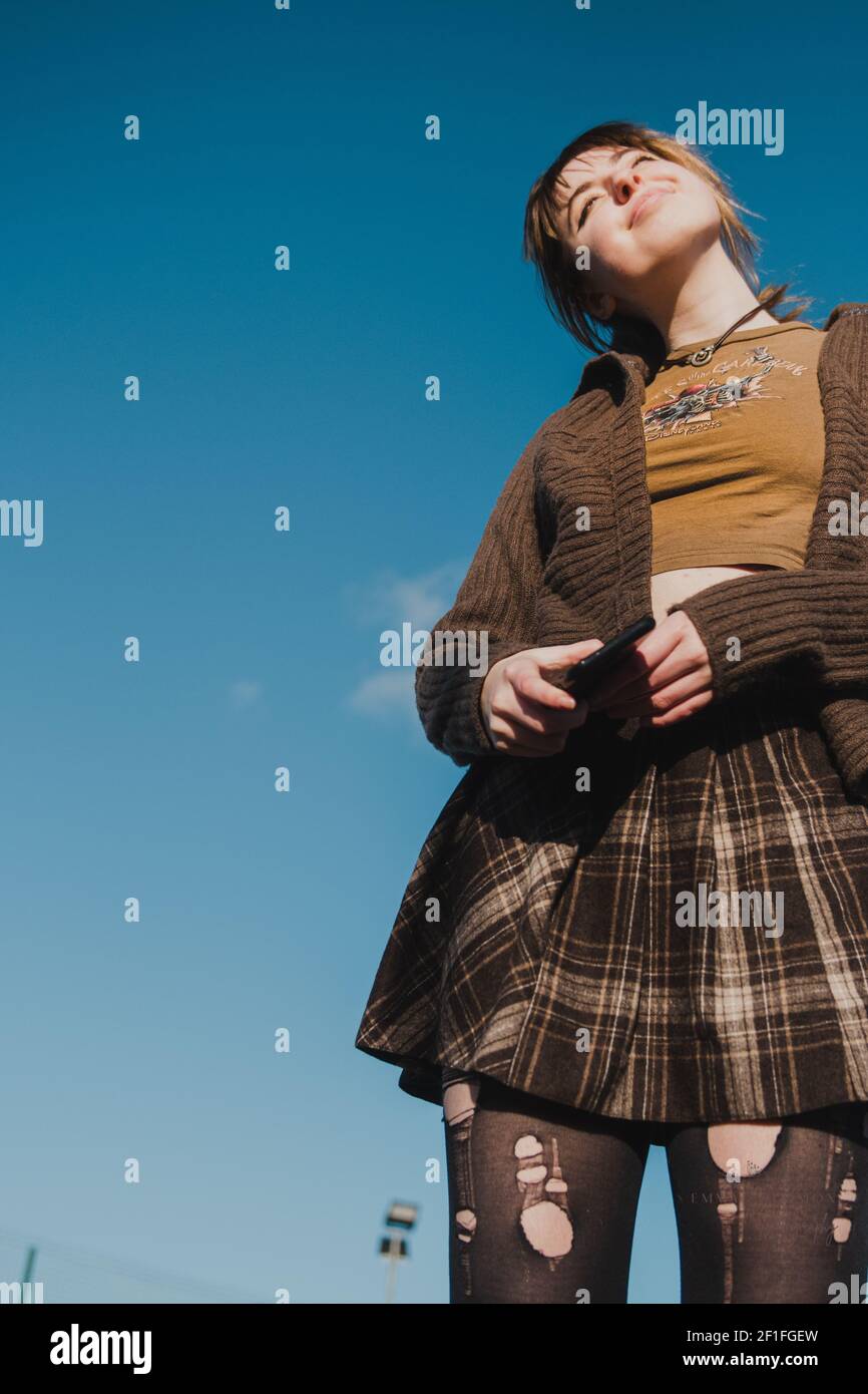 Portrait d'une jeune fille de patineuse en jupe tartan brune contre un ciel  bleu Photo Stock - Alamy