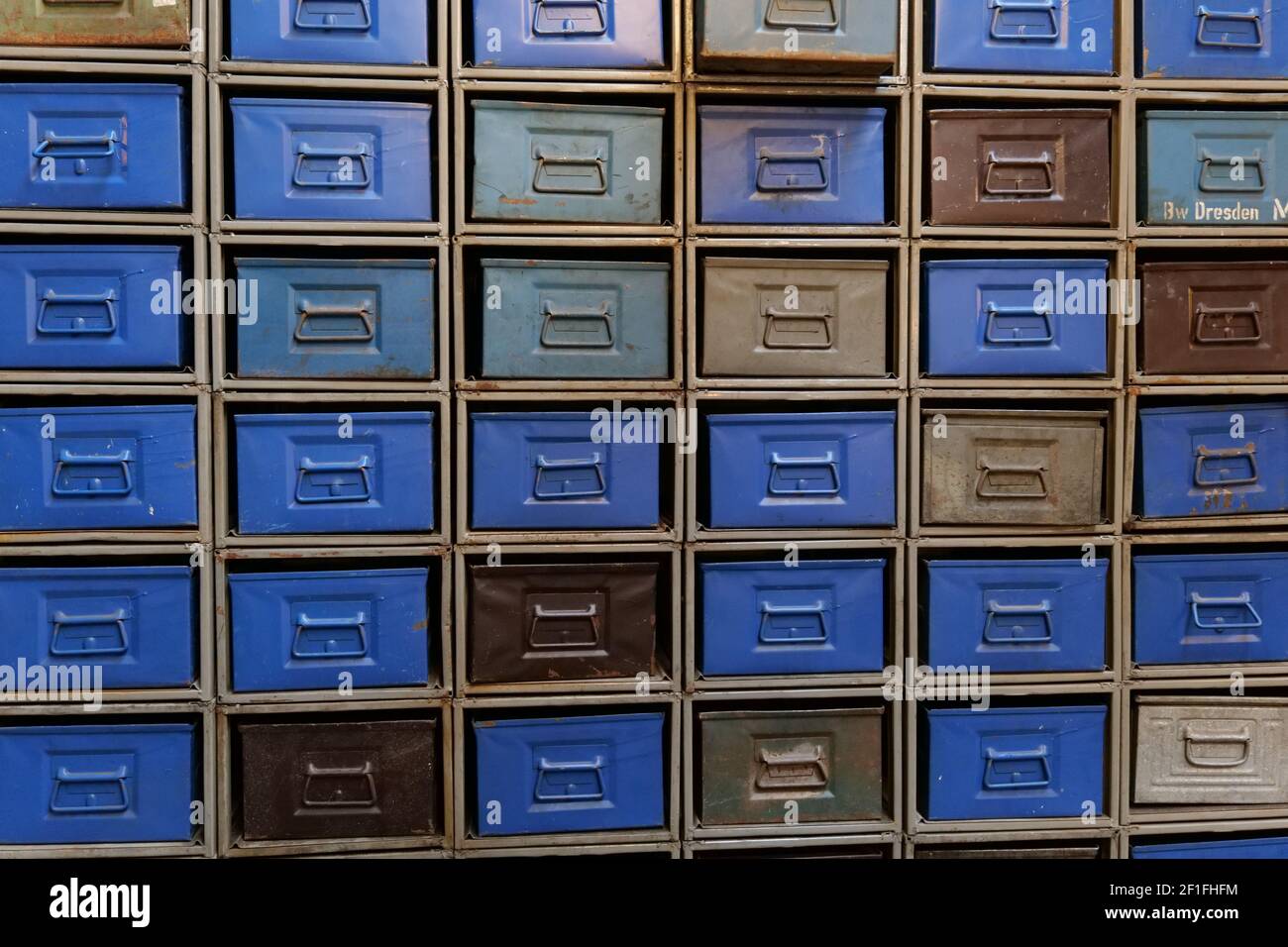 Un mur avec de nombreux tiroirs en métal bleu et brun vintage brillant. Photo prise sur un marché aux puces près de Treptower Park. Concept : stockage, base de données, documents, Banque D'Images