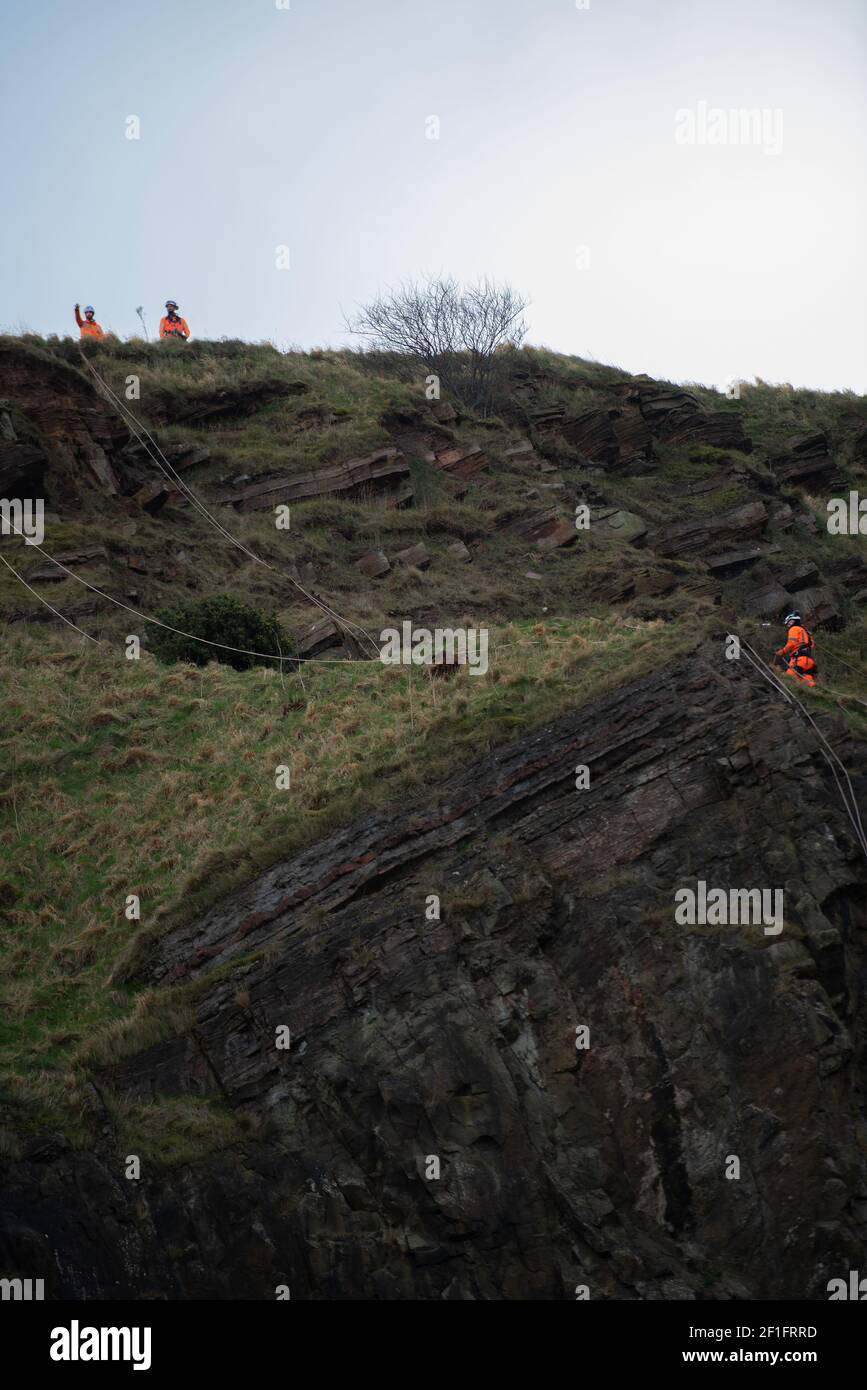 Édimbourg, Écosse, Royaume-Uni. 8 mars 2021. Un ouvrier se rendant à ses collègues au sommet de la « route radicale » sur Arthur's Seat, Édimbourg, 8 mars 2021. La route radicale est fermée en raison du risque continu de chute de roches. 65 tonnes de roche sont tombées sur le sentier en un an, selon l'Écosse historique qui surveille la situation. Credit: Gayle McIntyre/Alamy Live News Banque D'Images