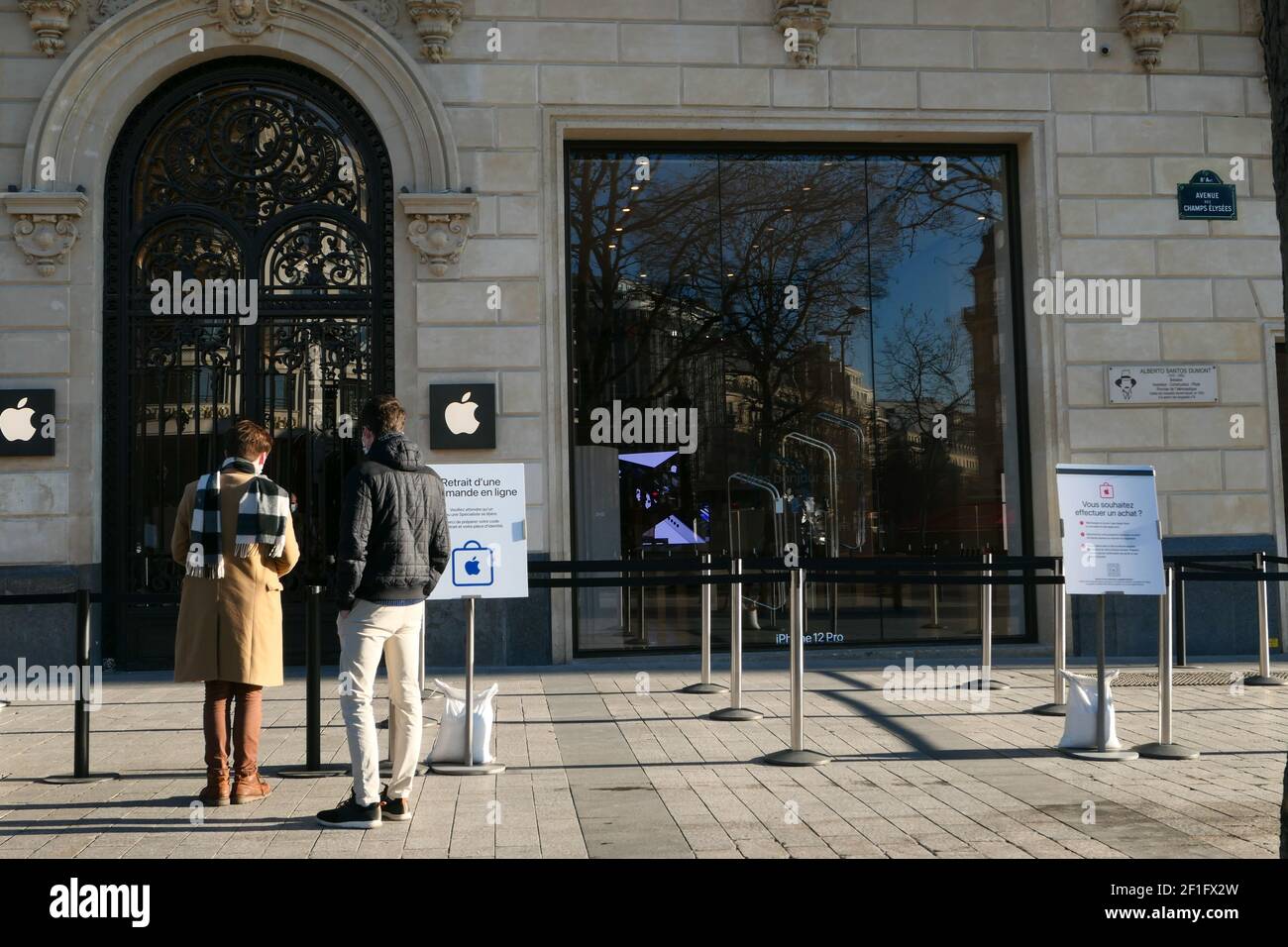 Paris, France. Mars 07. 2021. Deux hommes attendent l'ouverture d'un magasin de téléphone Apple sur l'avenue des champs-Élysées. Banque D'Images