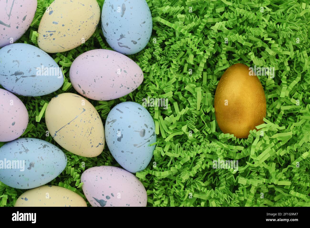 Collection d'œufs de Pâques colorés avec un seul œuf doré Banque D'Images