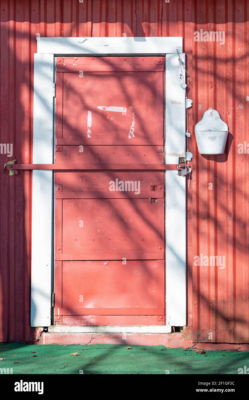 Ancienne porte en métal verrouillée de couleur rouge. Arrière-plan texturé, abstraction Banque D'Images