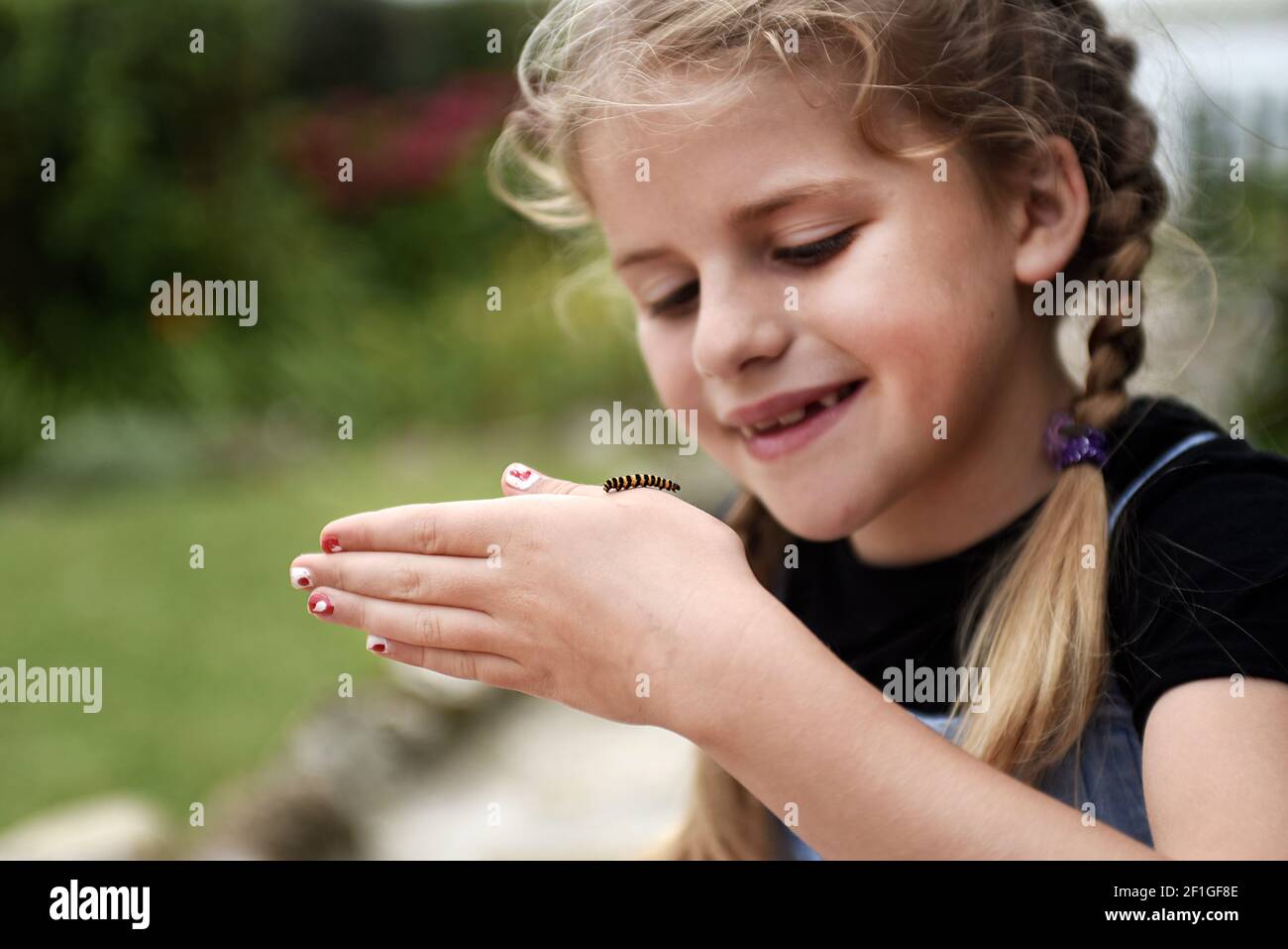 Caterpillar qui court à travers la main des filles Banque D'Images