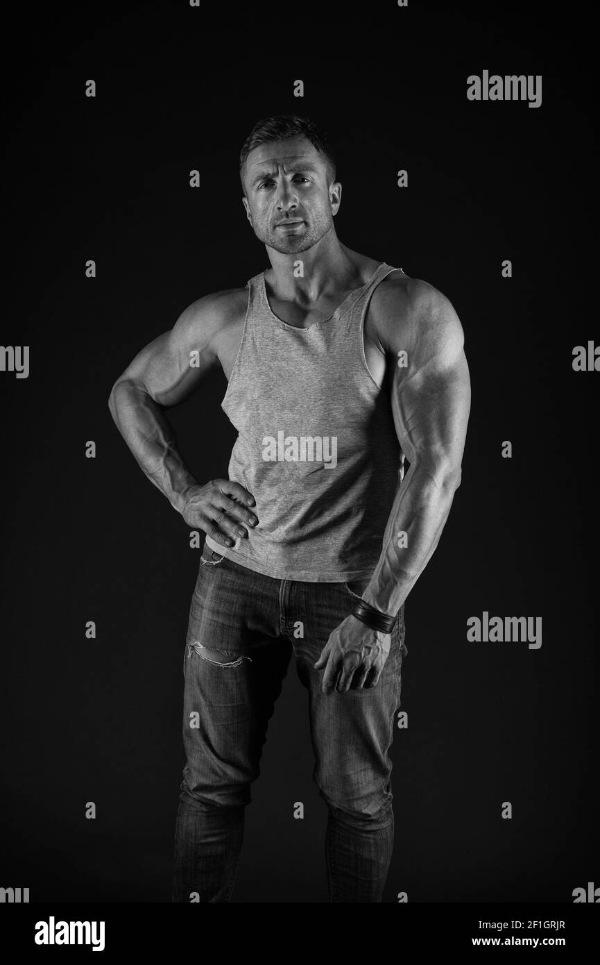 L'agitation pour gagner plus de muscle. S'adapte avec des bras musclés arrière-plan noir. Sportsman montre les triceps biceps en tenue décontractée. Formation de force musculaire. Culturisme et physique pour hommes. Sport et fitness. Banque D'Images