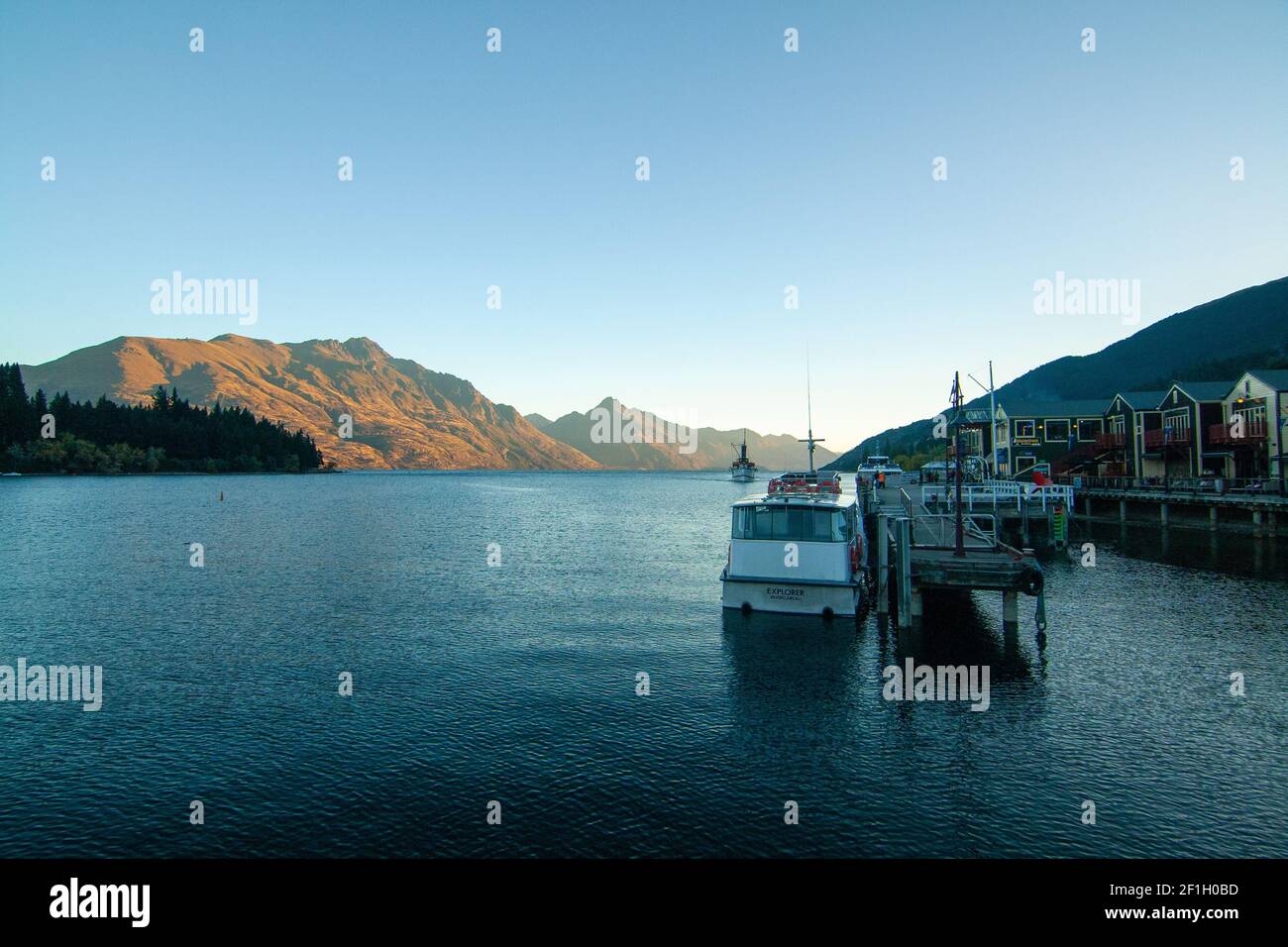 Queenstown Wharf and Harbour View of Lake Wakatipu and Mountain Peaks at Sunset Lights on background, New Zealand, South Island Banque D'Images