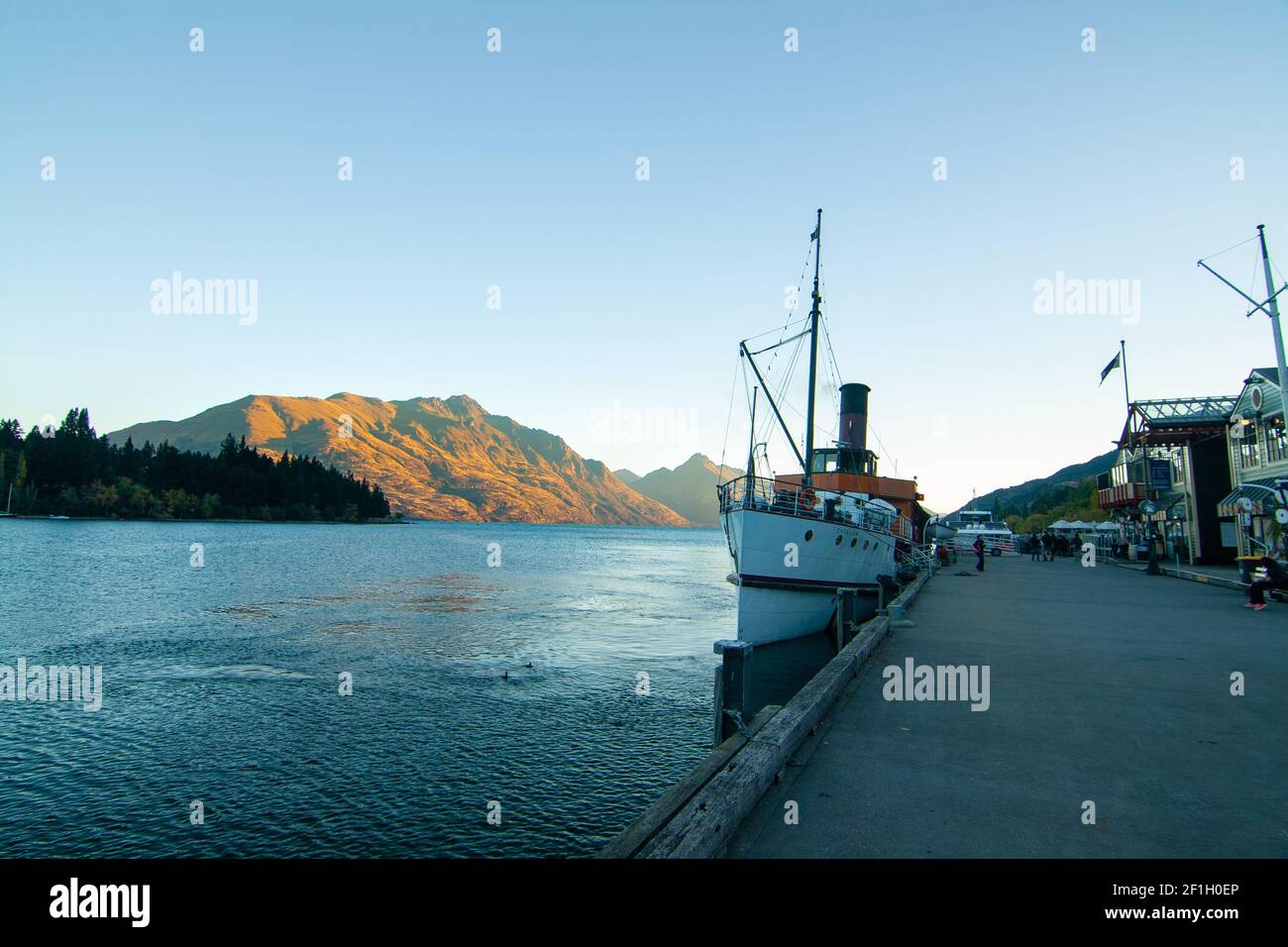 Soirée au quai de Queenstown avec bateau à vapeur sur le lac Wakatipu, coucher de soleil sur les montagnes de bakground, Nouvelle-Zélande, Île du Sud Banque D'Images