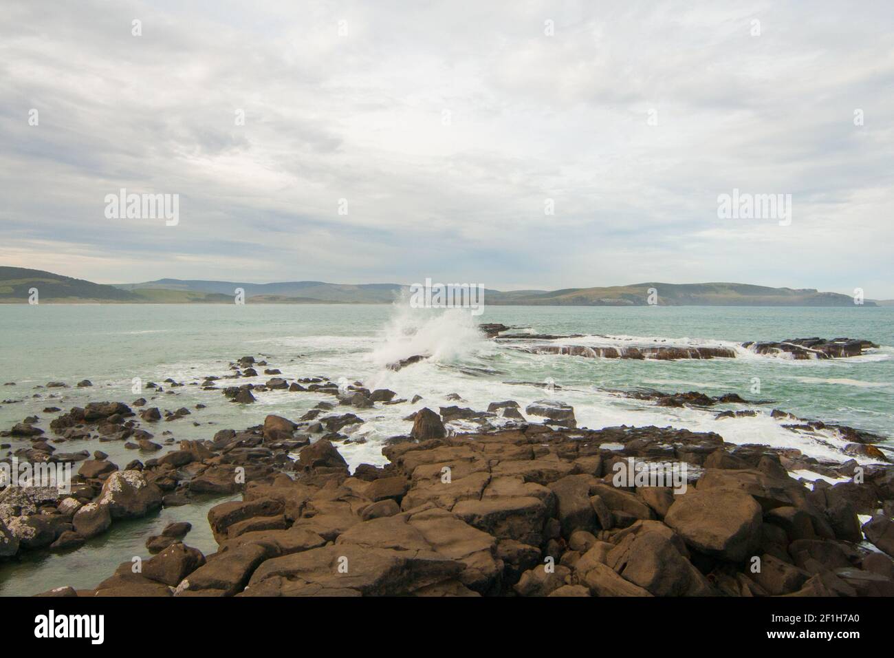 Vagues de l'océan Pacifique écrasant sur des rochers et éclaboussant l'eau autour de la baie de Porpoise en Nouvelle-Zélande, les Catlins Banque D'Images