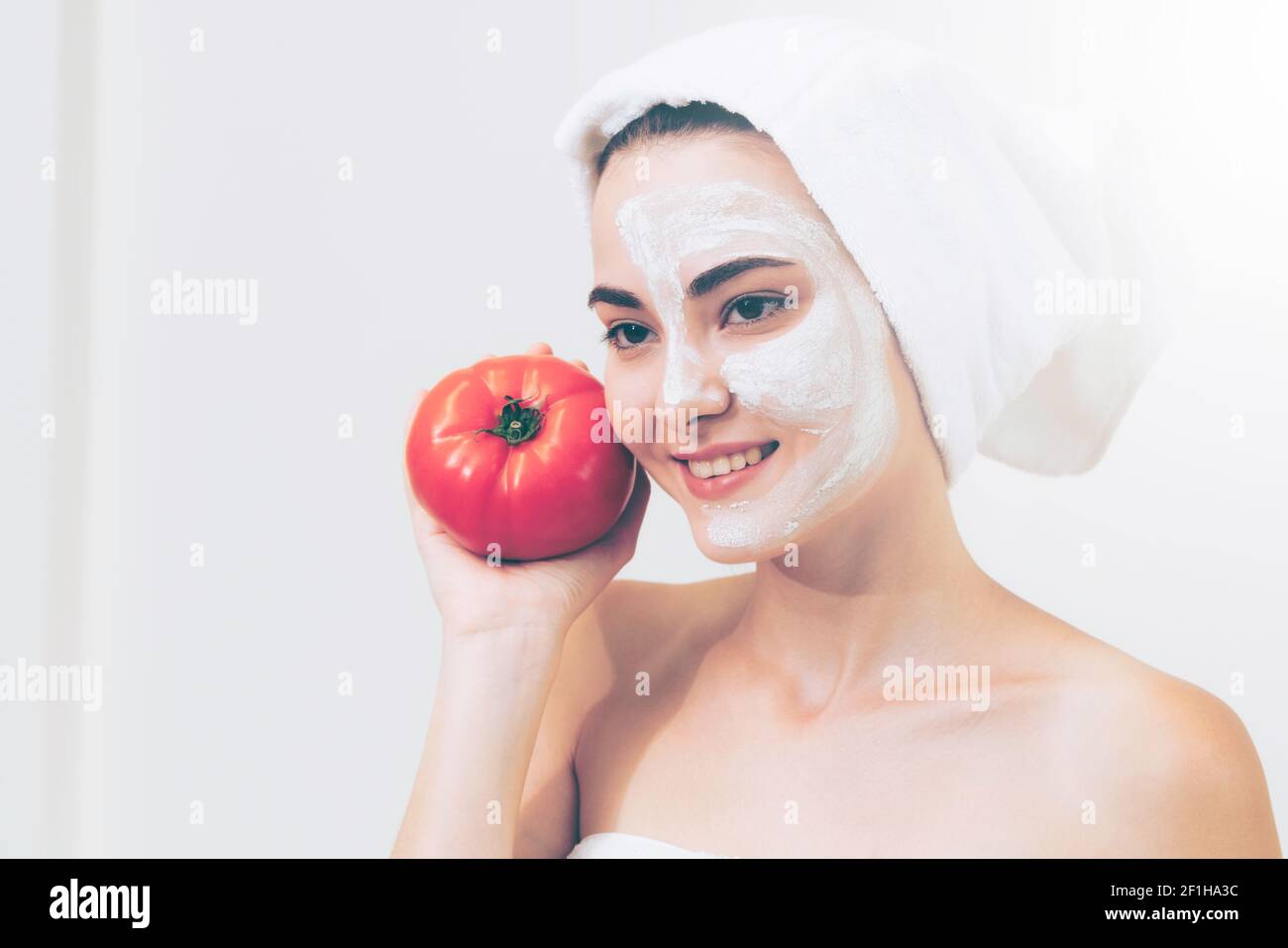 Belle femme ayant un traitement de masque facial avec extrait de crème de tomate montrant l'avantage du traitement de la nature. Cosmologie anti-âge, soins du visage Banque D'Images