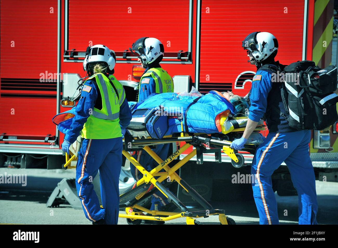 Suite à un grave accident de voiture, une victime est livrée, via un brancard, à un hélico en attente pour le transport vers un hôpital de banlieue de Chicago. Banque D'Images