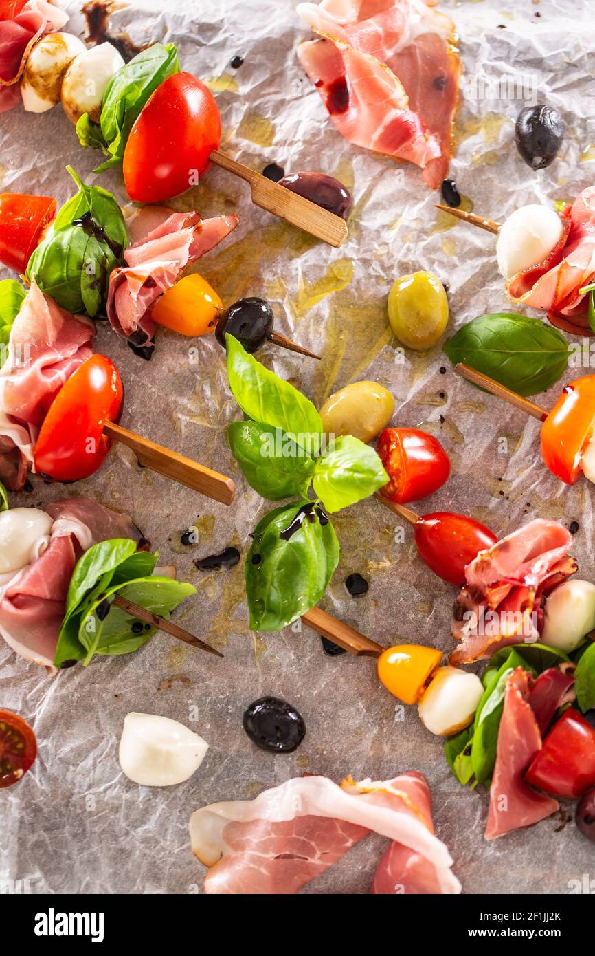 Brochettes de Caprese tomates italiennes ou méditerranéennes mozzarella olives et prosciutto Banque D'Images