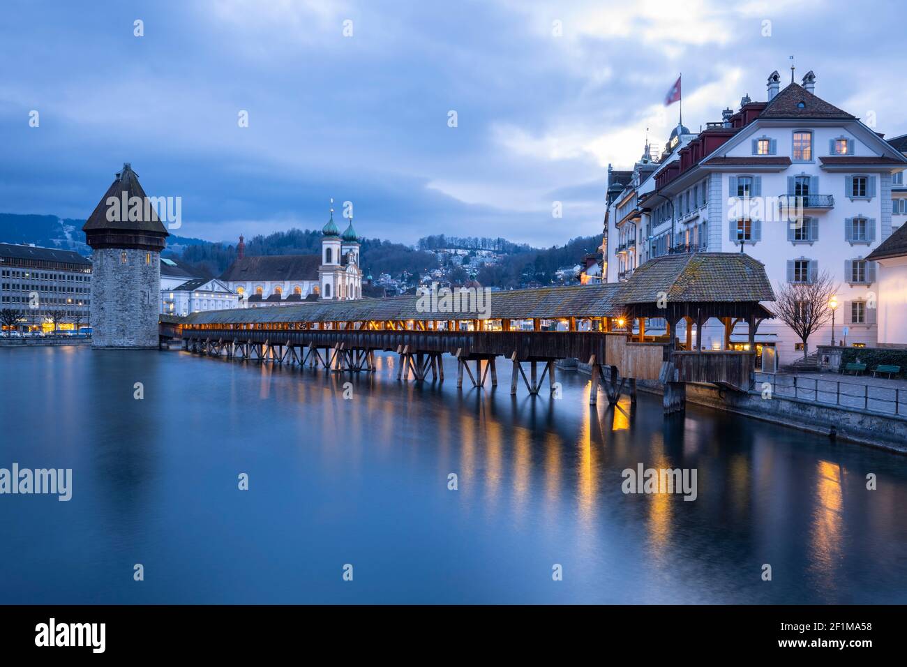 Vue sur le pont de Kapellbrücke, l'église jésuite et la Wasserturm qui se reflète sur la rivière Reuss. Lucerne, canton de Lucerne, Suisse. Banque D'Images