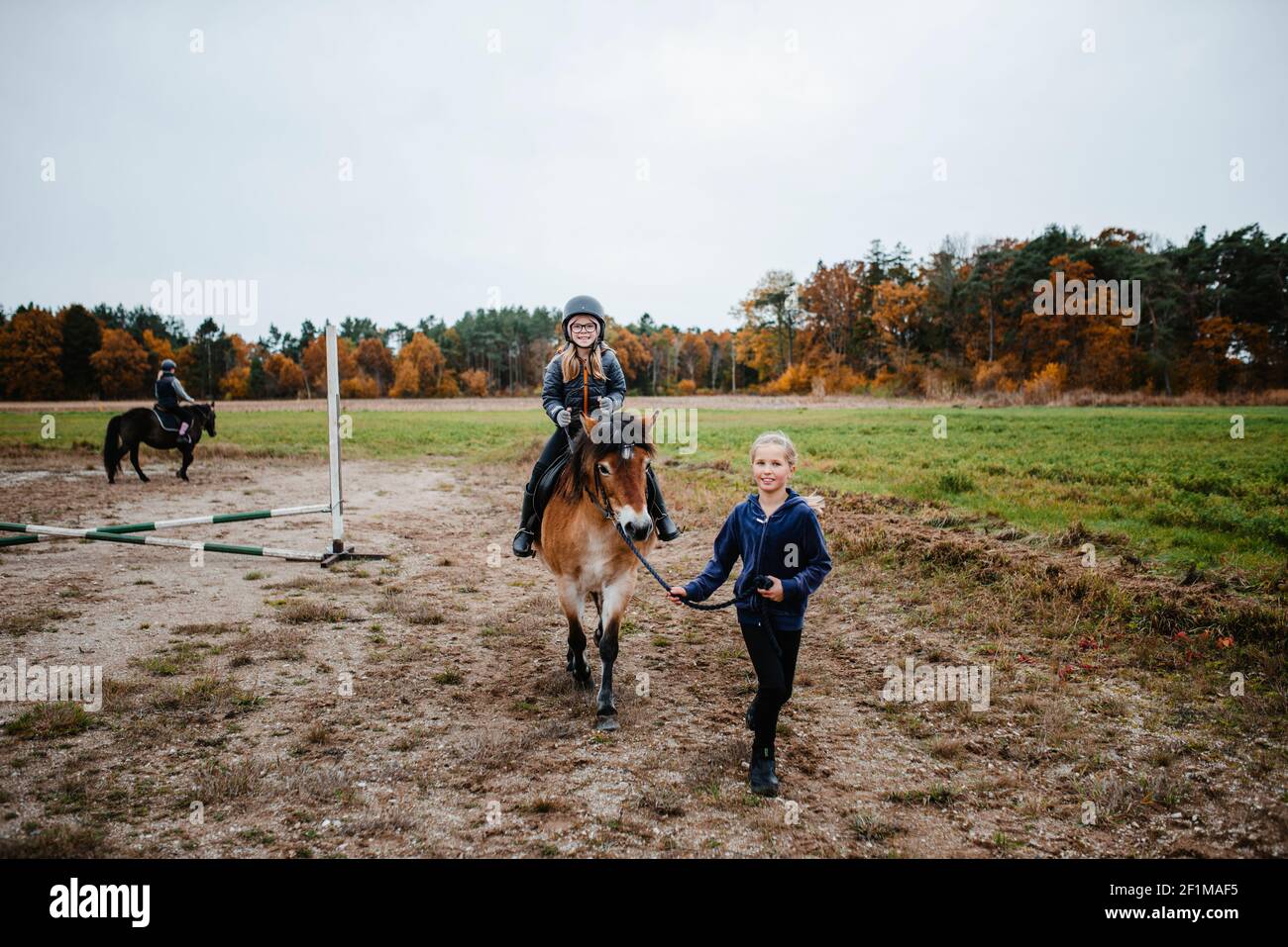 Une fille qui fait du poney sur le paddock Banque D'Images