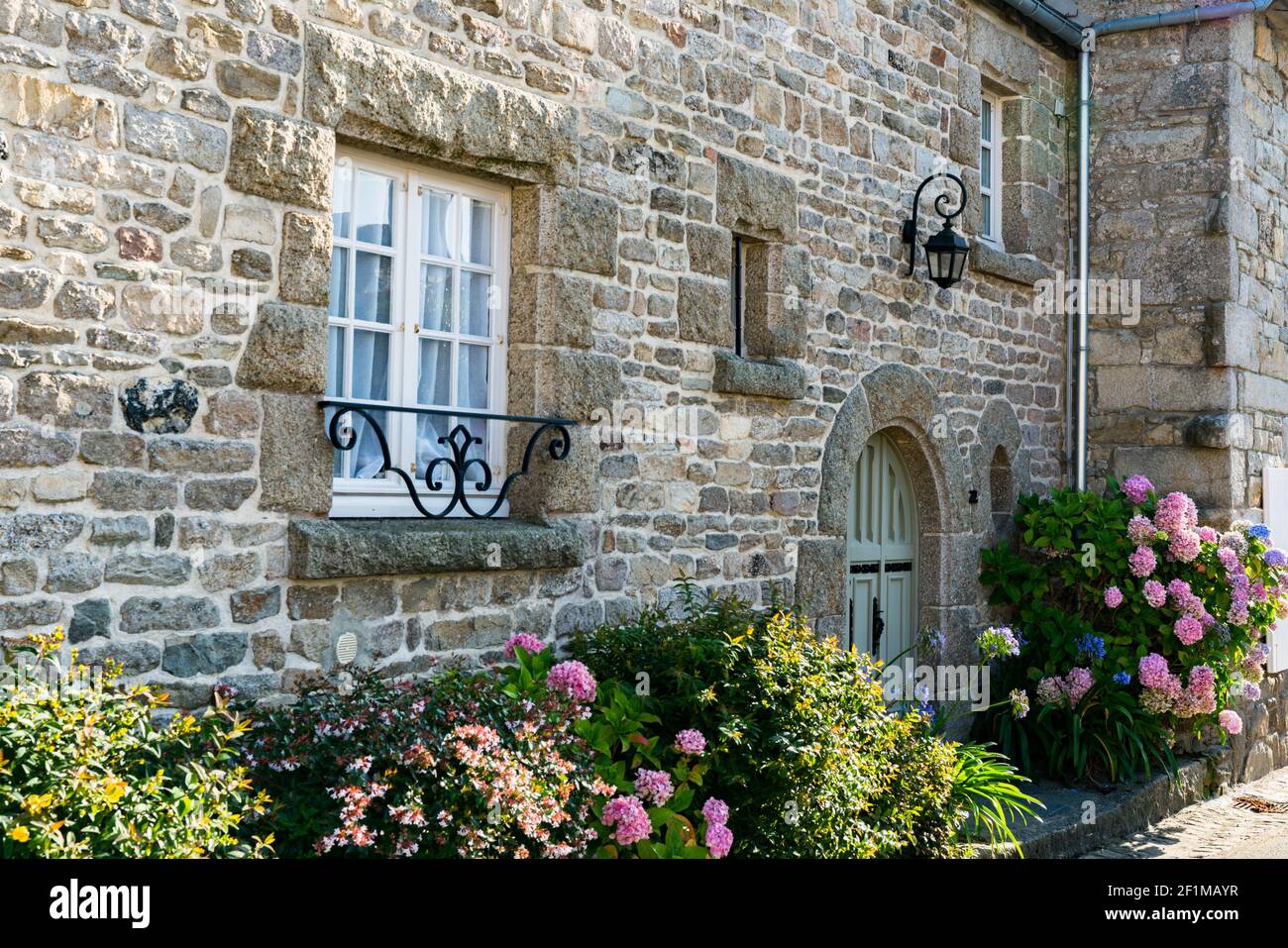 Façade typique de maison en pierre en Bretagne avec fleur d'hortensia colorée lits Banque D'Images