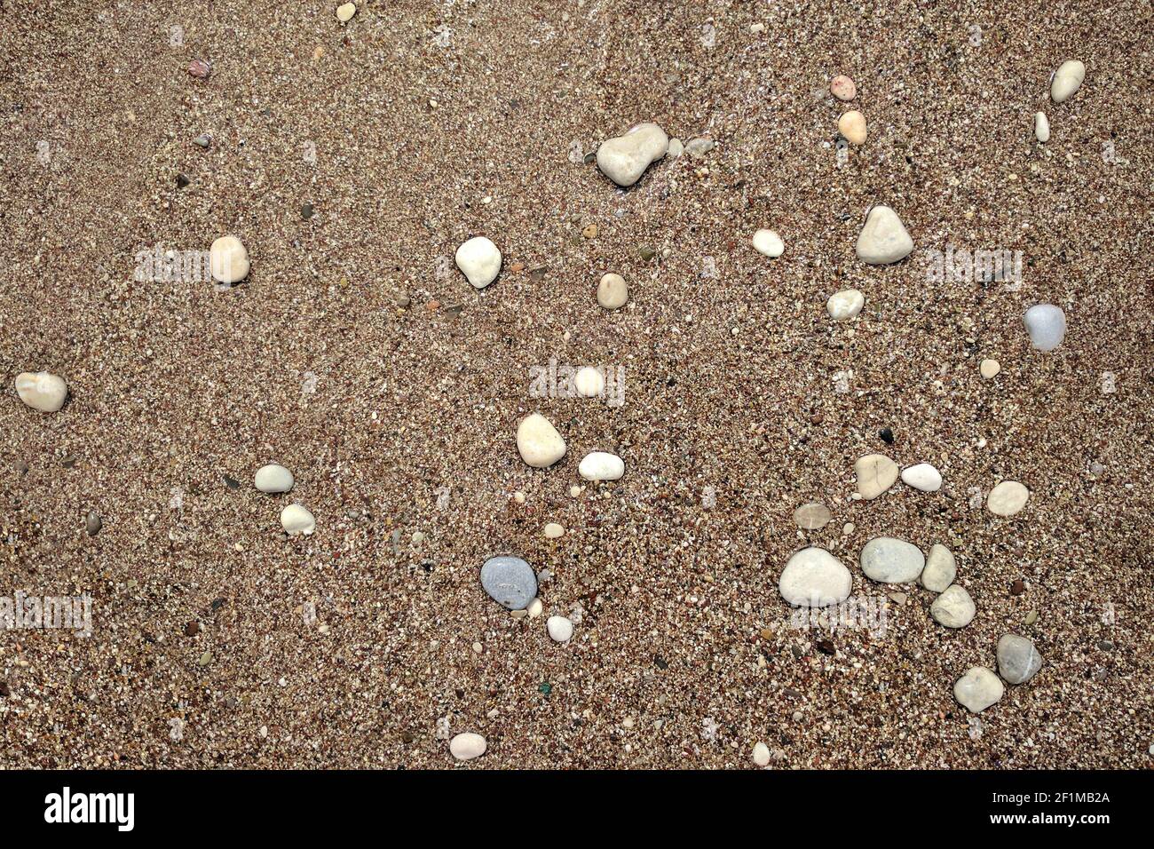 Plage de sable propre avec des pierres multicolores de différentes formes et tailles Banque D'Images