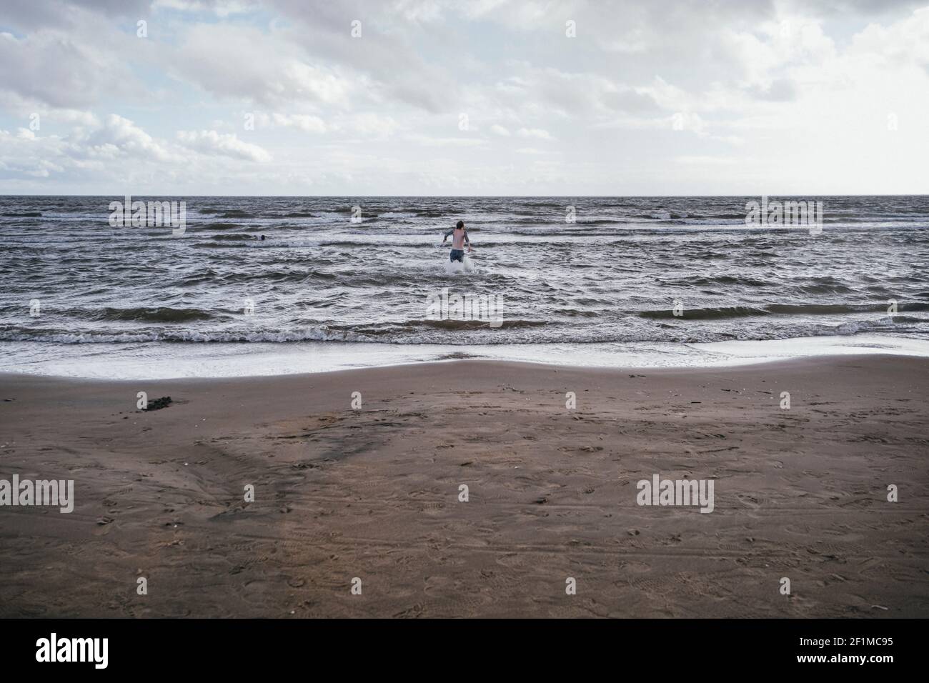 Vue sur la plage de sable, personne en mer en arrière-plan Banque D'Images