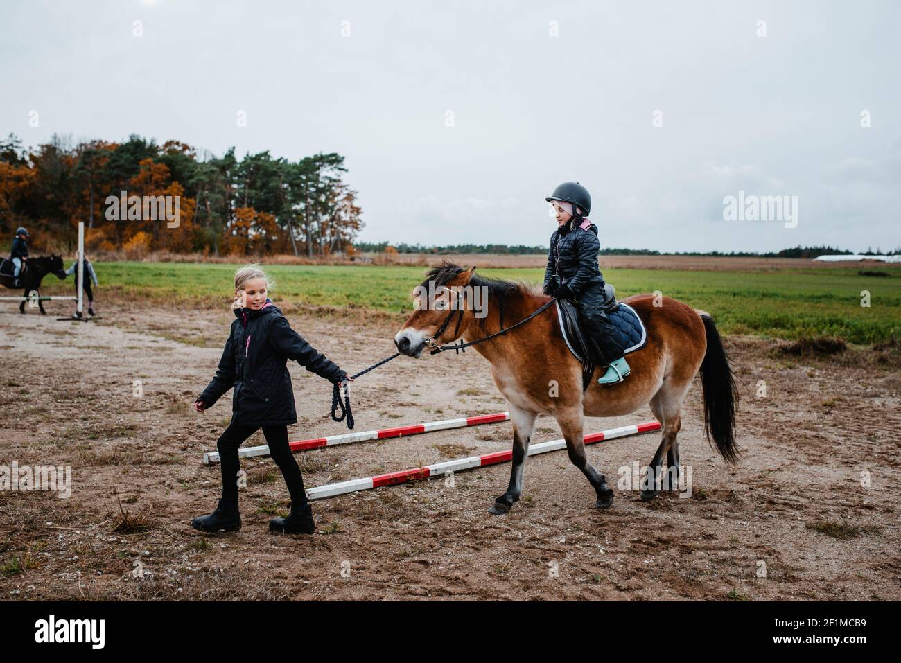 Une fille qui fait du poney sur le paddock Banque D'Images