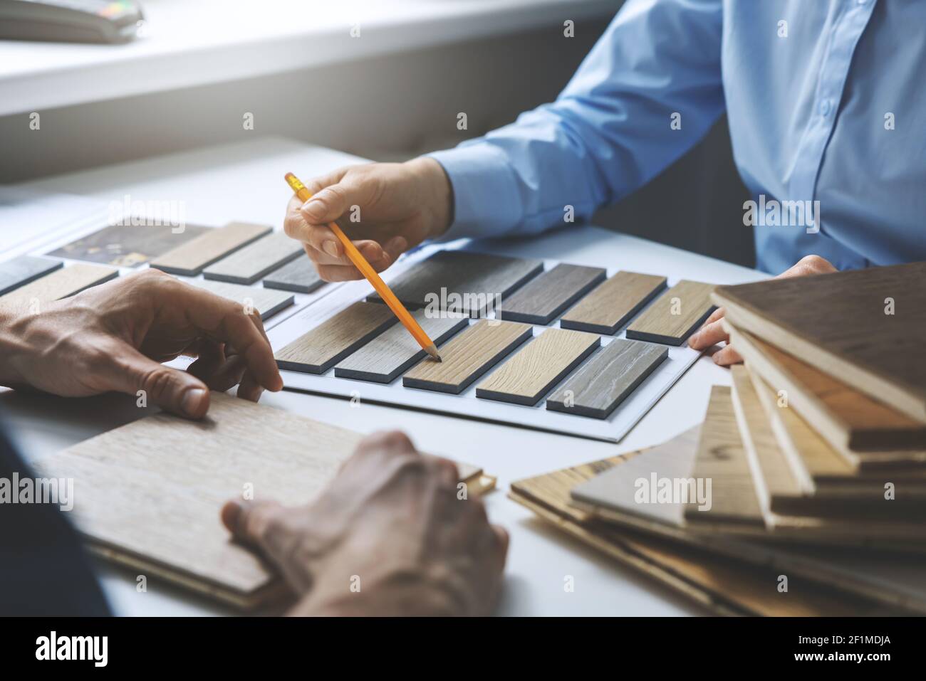 vendeur et client choisissant des textures de matériaux de meubles et de planchers de échantillons à l'atelier de design d'intérieur Banque D'Images