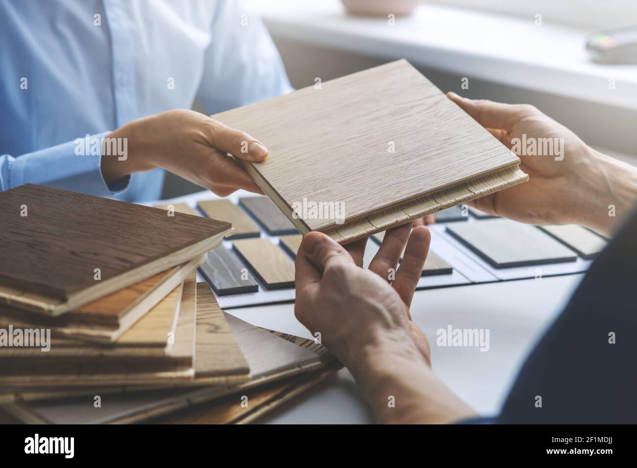 client choisissant un parquet en chêne 3 couches à partir d'échantillons au sol stocker Banque D'Images