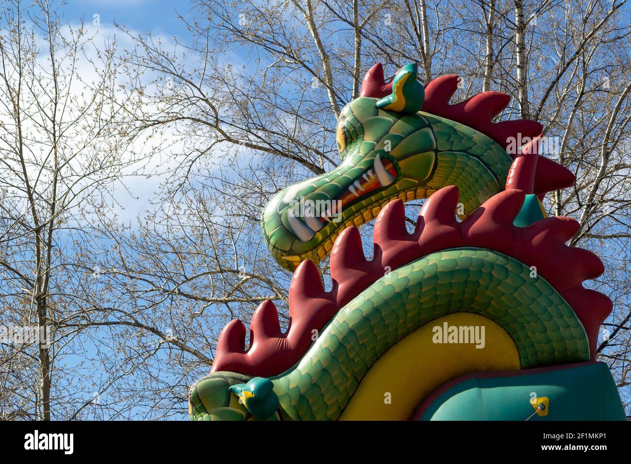 la tête d'un dragon gonflable face aux arbres de bouleau et ciel bleu Banque D'Images