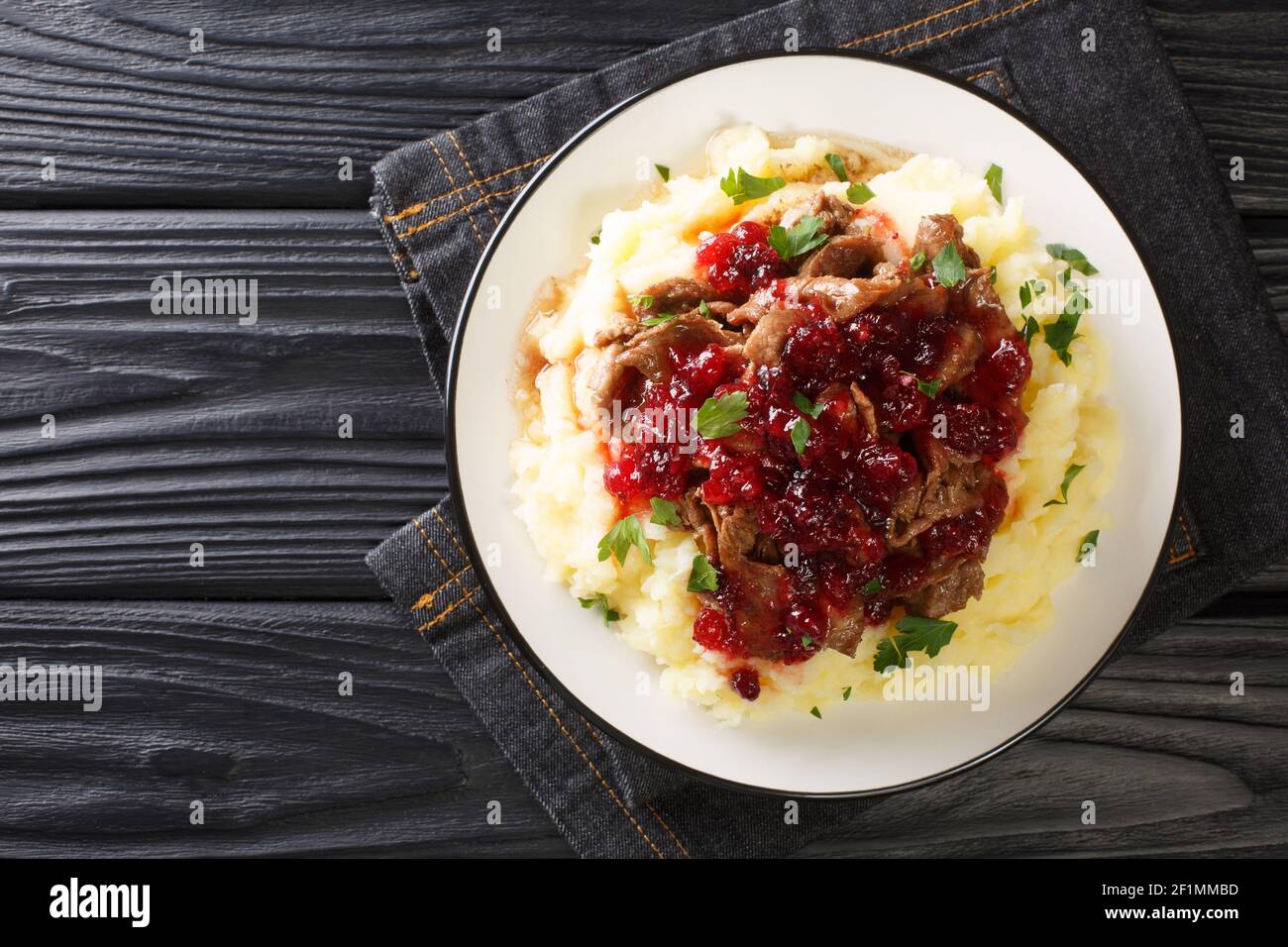 Cuisine de Laponie Poronkaristys venison avec purée de pommes de terre et sauce aux baies de lingonyre dans une assiette sur la table. Vue horizontale dessus Banque D'Images