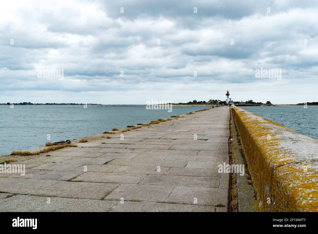 Long quai en pierre menant au phare du port de Saint-Vaast-la-Hogue En Normandie Banque D'Images