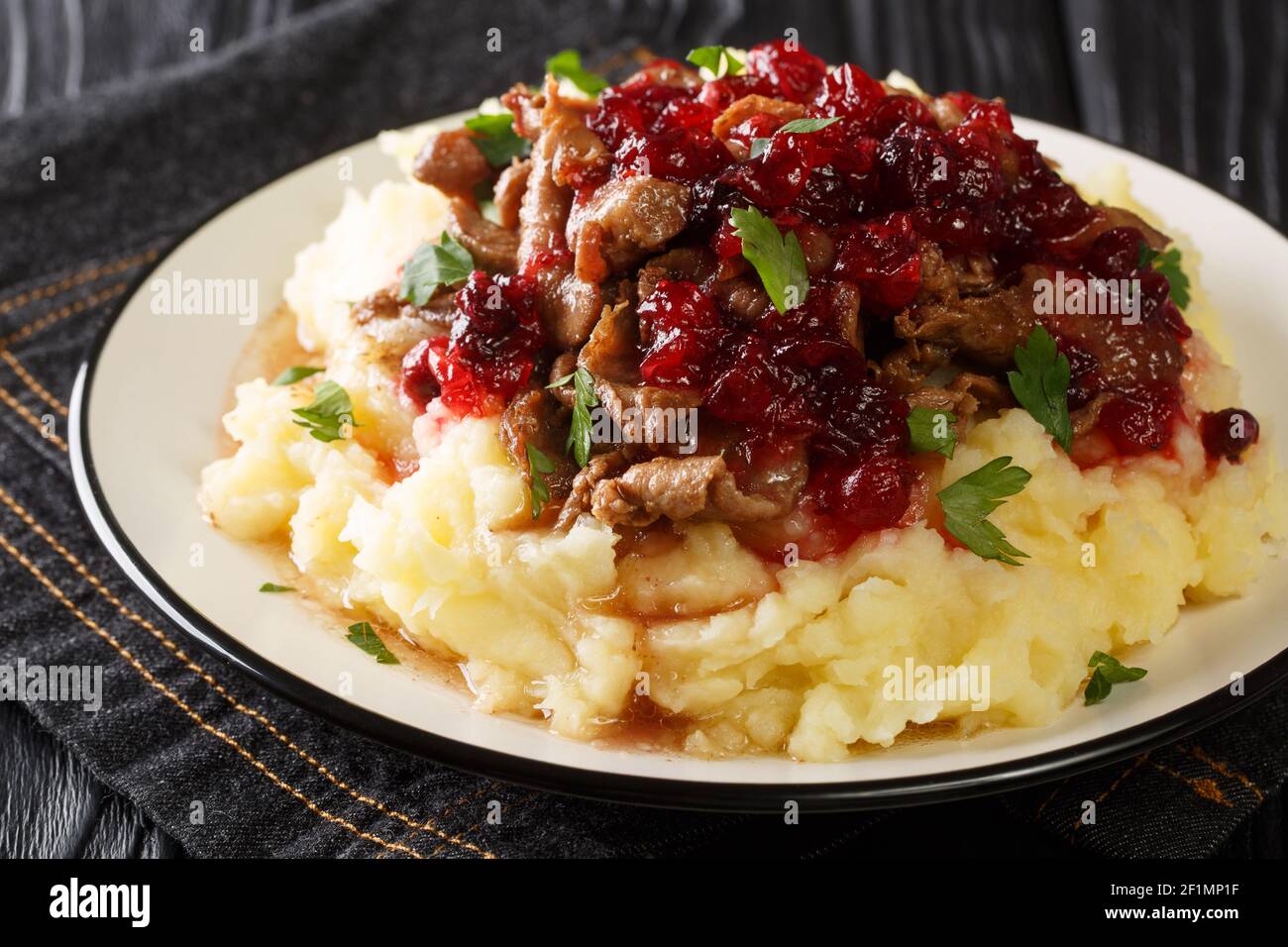Nourriture de Laponie Poronkaristys venison avec purée de pommes de terre et sauce aux baies de lingonyre dans une assiette sur la table. Horizontale Banque D'Images
