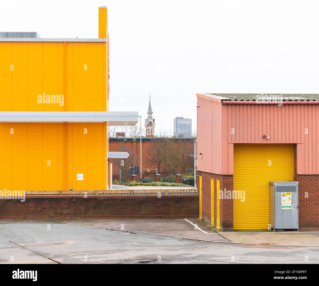 Unités d'entrepôt en carton ondulé jaune vif, rose, mur en brique. Sur le vieux marché du bétail (domaine industriel commun de Freemen) montre l'horloge de la maison de comptage. Banque D'Images