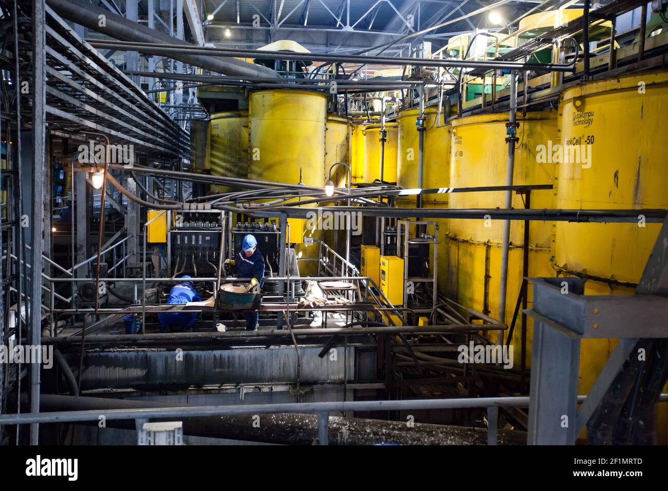 Koktau, province d'Aktobe, Kazakhstan - 06 mai 2012 : usine de concentration de minerai de cuivre. Équipement de technologie Outokumpu. Deux ouvriers sur des chars jaunes backgro Banque D'Images