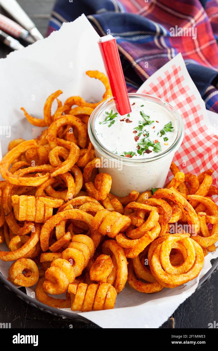 Frites bouclés, frites torsadées avec sauce Banque D'Images