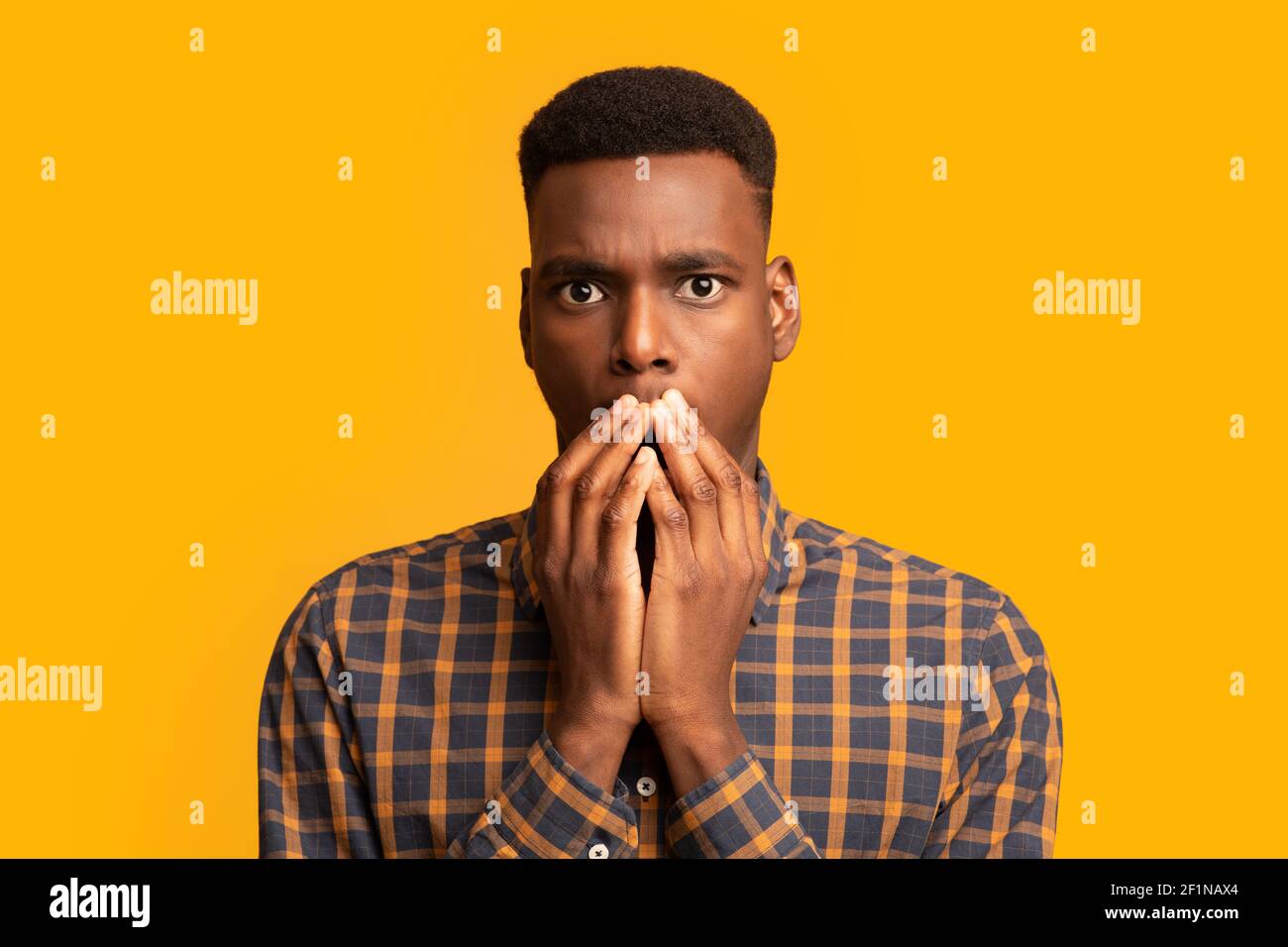 Pas de chemin. Choqué Africain américain Guy couvrant la bouche avec les mains et regardant caméra avec concerné, debout Speachless sur fond jaune, Emoti Banque D'Images