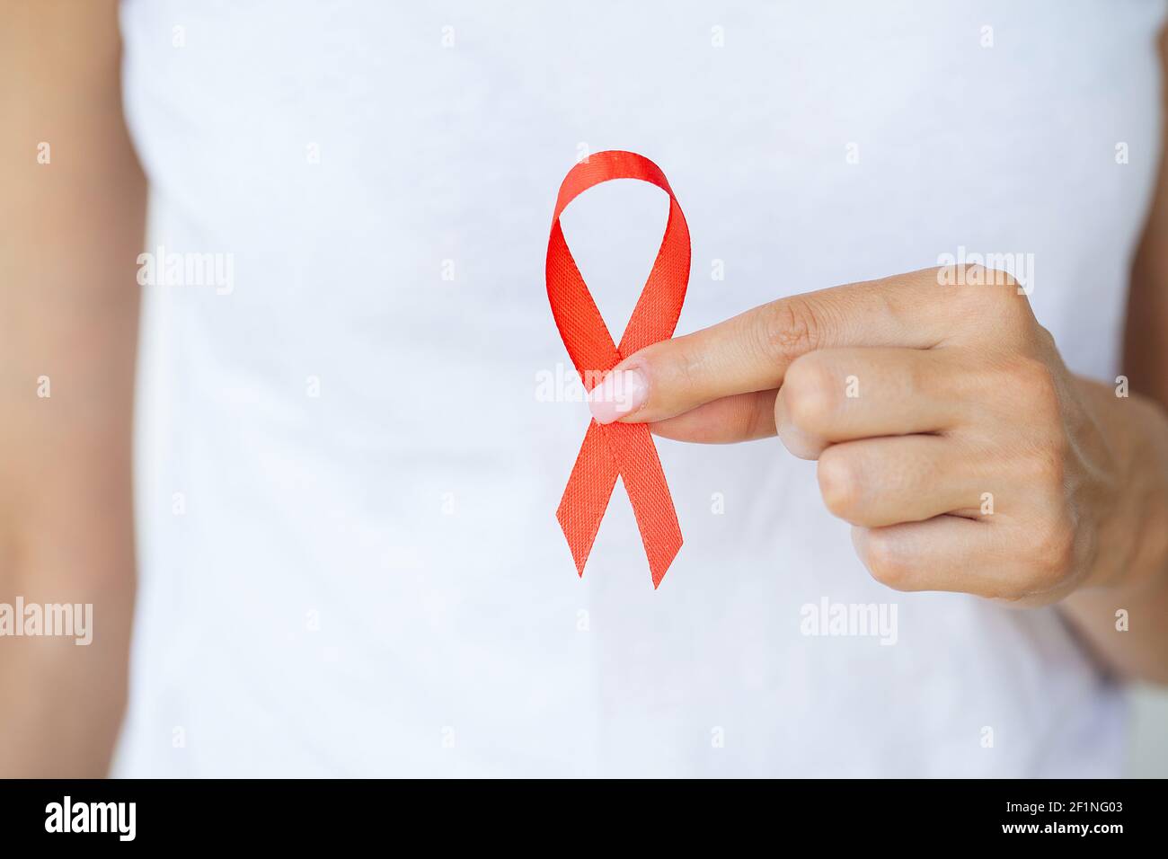 Femme tenant le ruban rouge VIH, ruban de sensibilisation de la Journée  mondiale du sida Photo Stock - Alamy