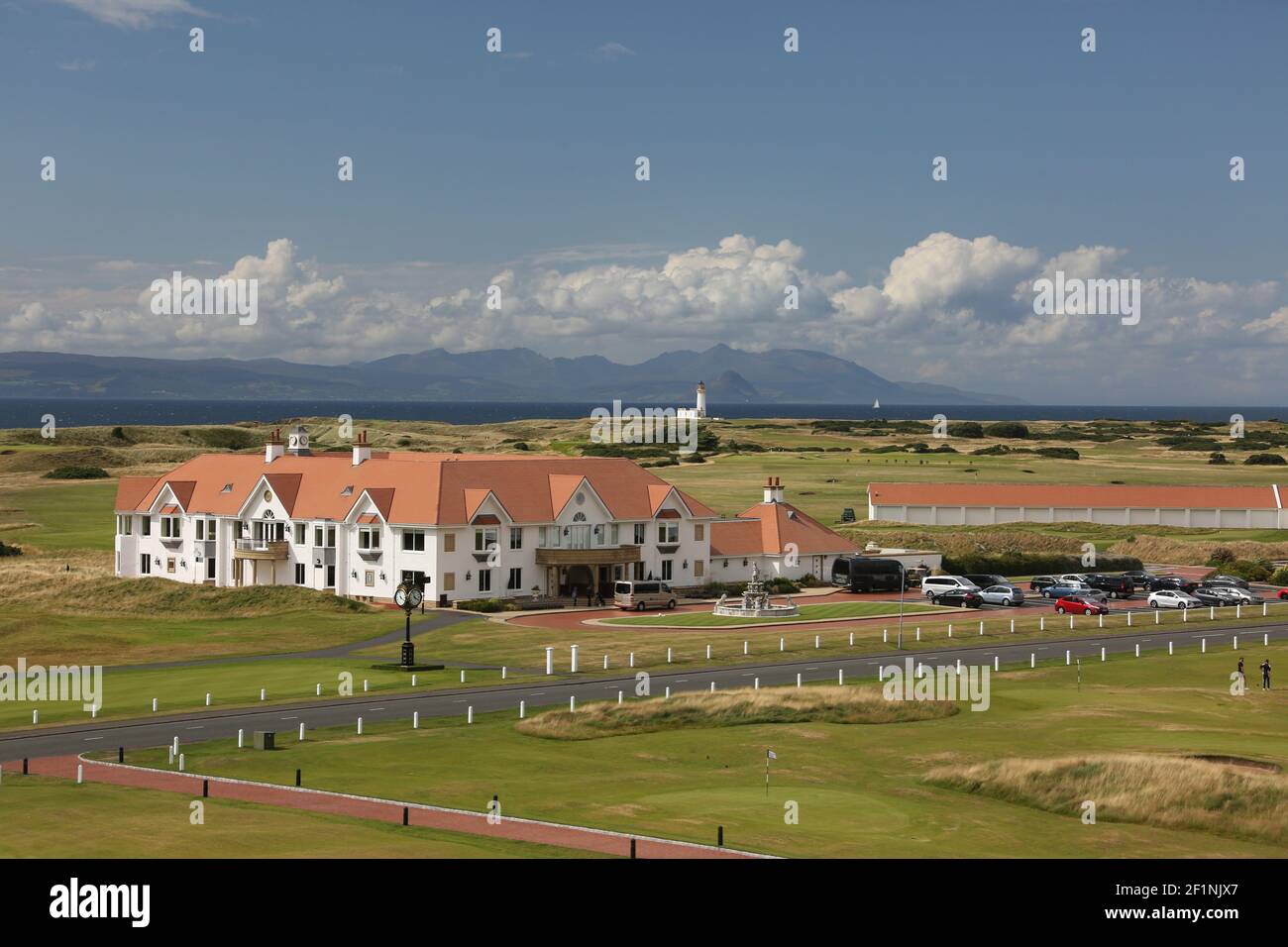 Turnberry Golf Club, South Ayrshire, Écosse, Royaume-Uni. Le célèbre parcours de golf de Trump Turnberry se trouve sur une magnifique péninsule de liens terrestres sur la côte du South Ayrshire, avec des vues spectaculaires sur le Firth de Clyde jusqu'aux îles d'Arran et Ailsa Craig, le Mull de Kintyre et même l'Irlande par temps clair. Vue sur le club, le phare et l'île d'Arran depuis le Trump Turnberry Hotel Banque D'Images