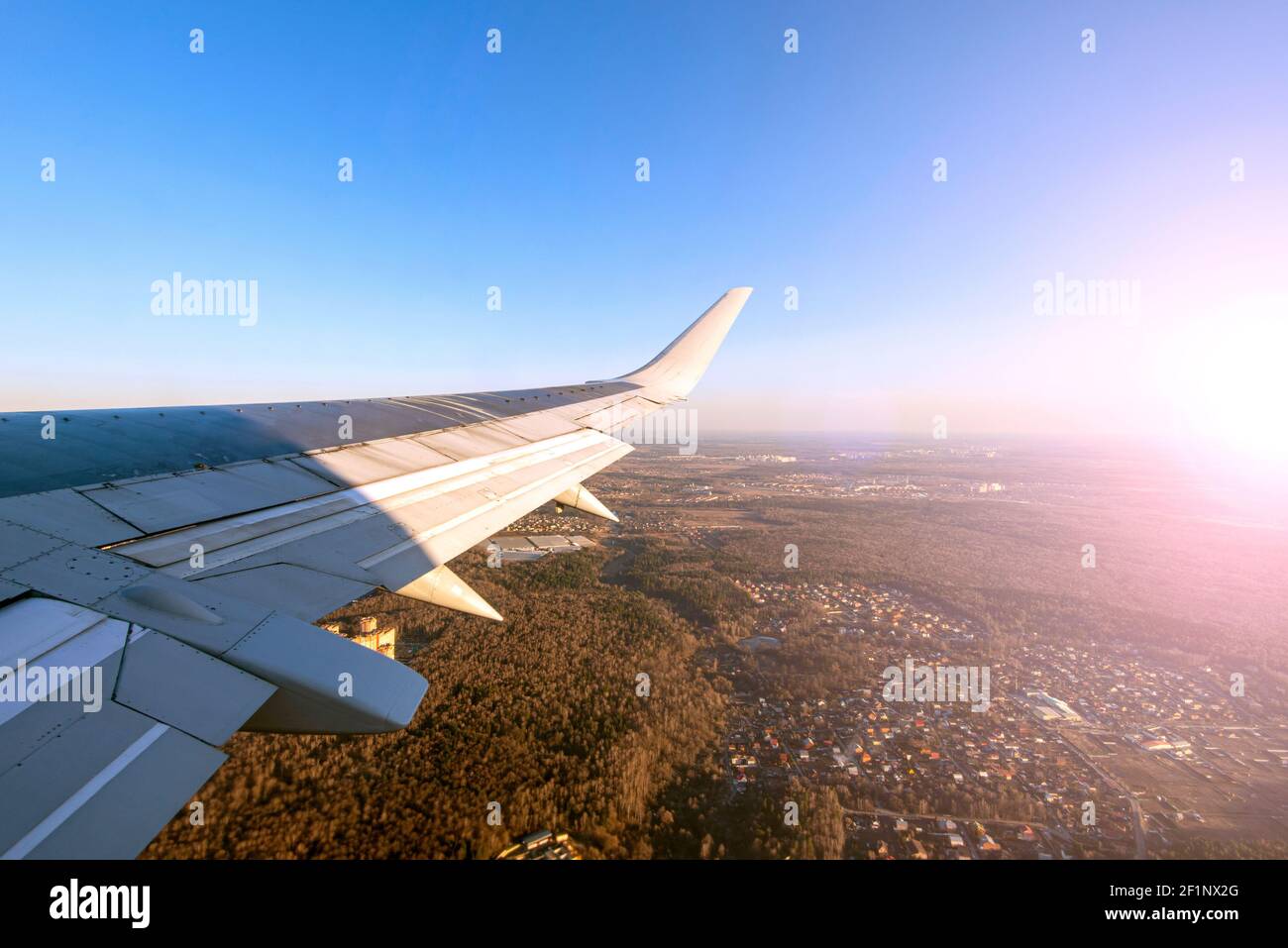 Avion en train d'atterrir. Vue depuis la fenêtre de l'avion sur l'aile pendant le coucher du soleil Banque D'Images
