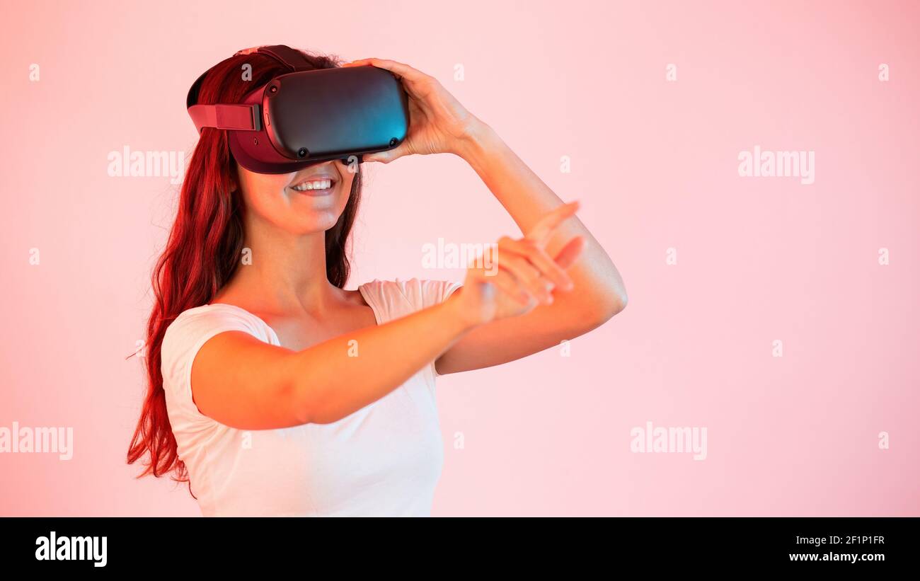 Femme en réalité virtuelle qui étire sa main et touche quelque chose avec le doigt Banque D'Images