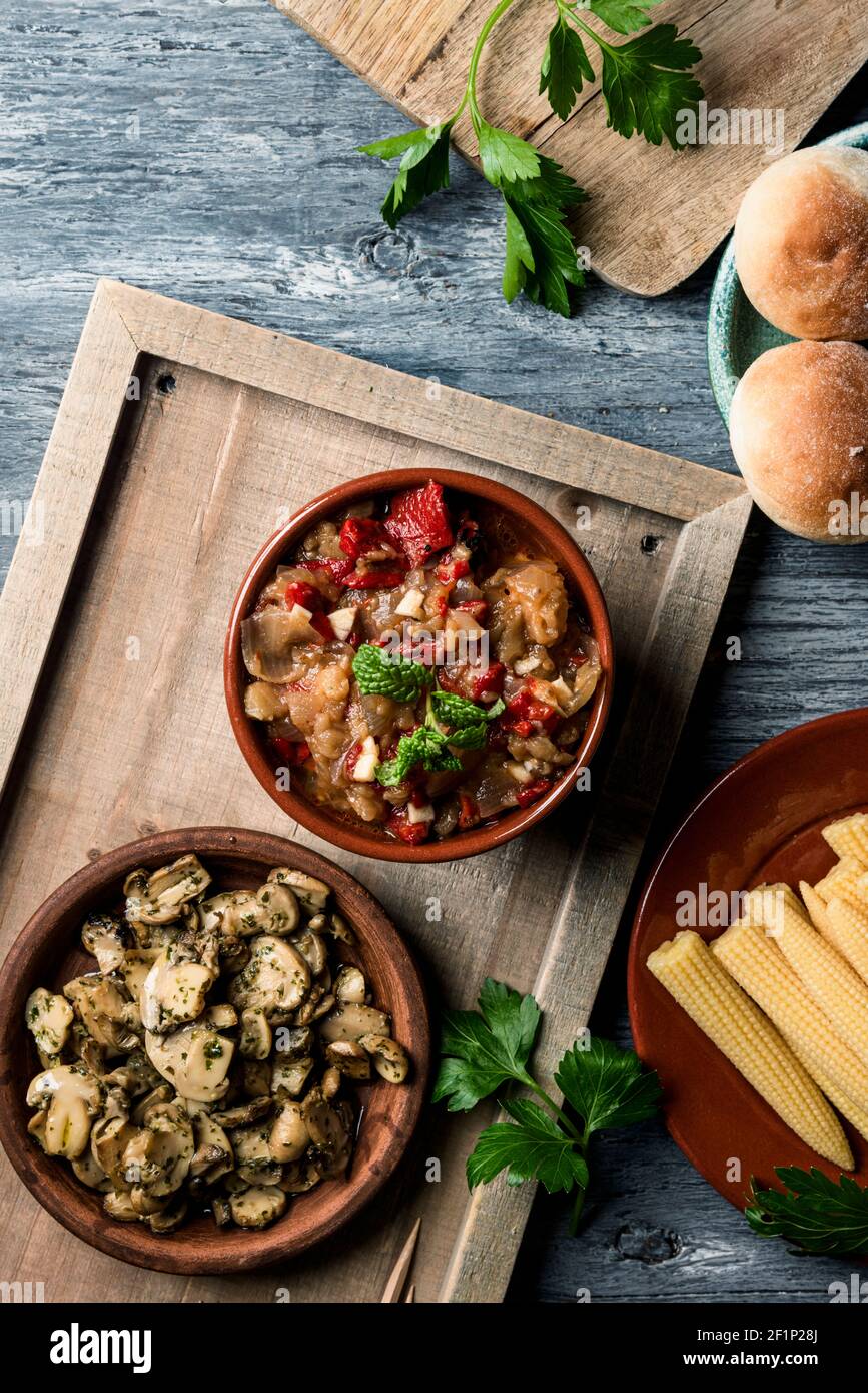 vue en grand angle d'un bol avec un peu d'escalivada espagnol, fait avec différents légumes rôtis, sur une table à côté de quelques petits pains, une assiette avec certains Banque D'Images