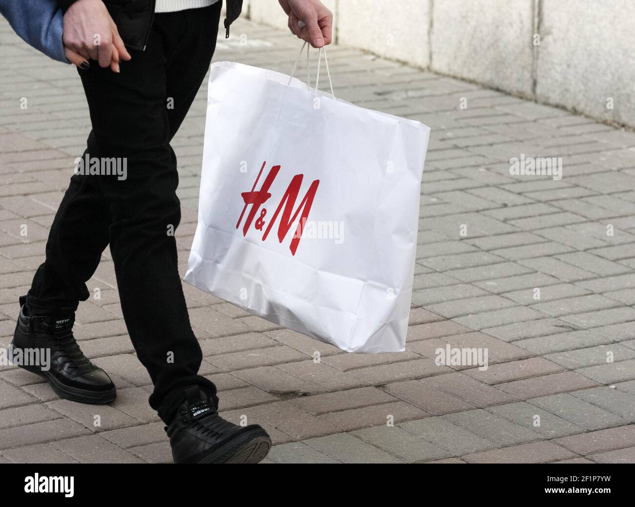 Kiev, Ukraine. 06e mars 2021. Un acheteur tenant un sac avec le logo H & M ( Hennes & Mauritz) d'une société suédoise de vente de vêtements dans sa main  dans une rue
