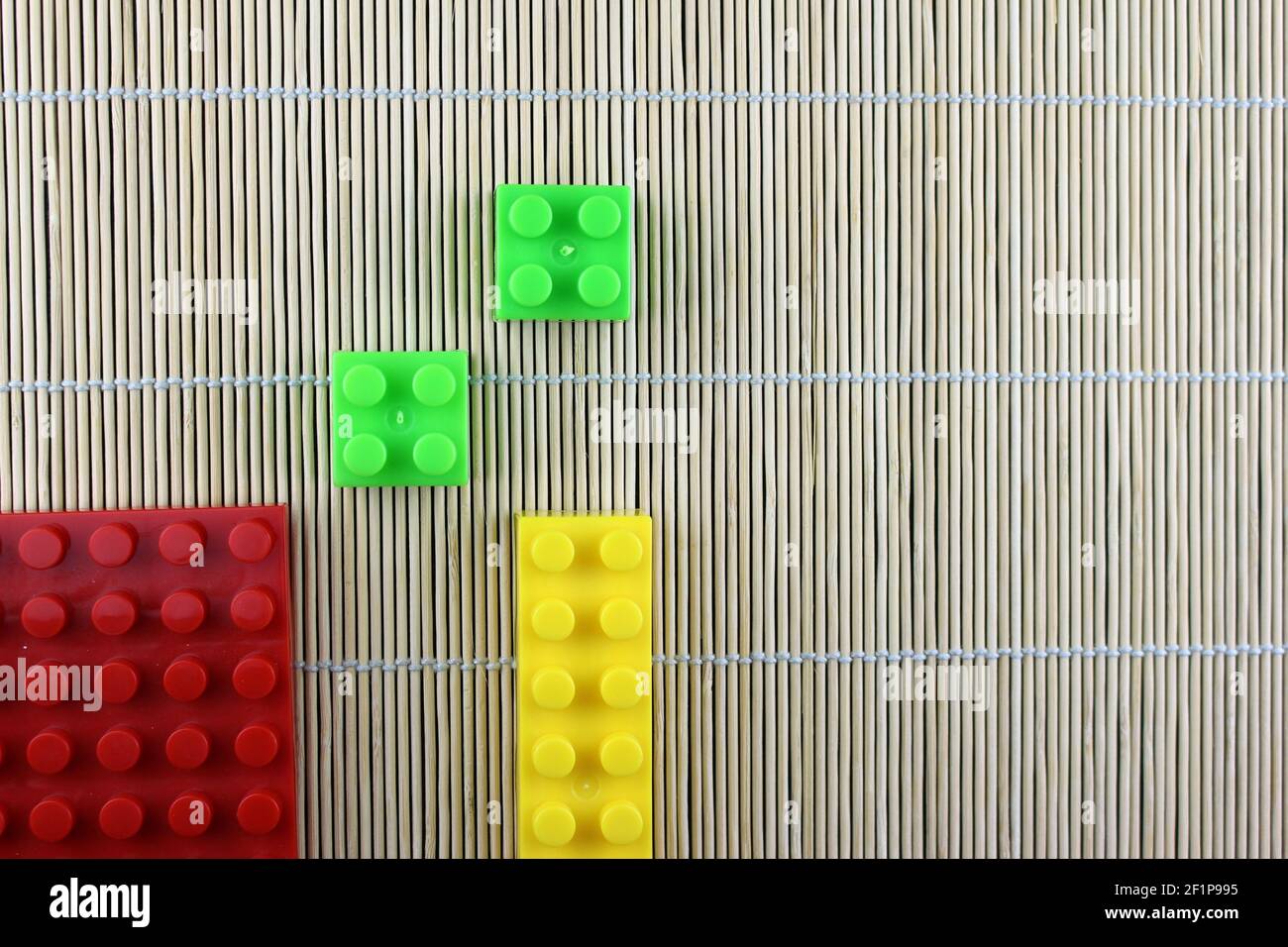 Jeu abstrait LEGO, tapis en osier, serviette décorative de fines tiges fixées avec un fil textile. Banque D'Images