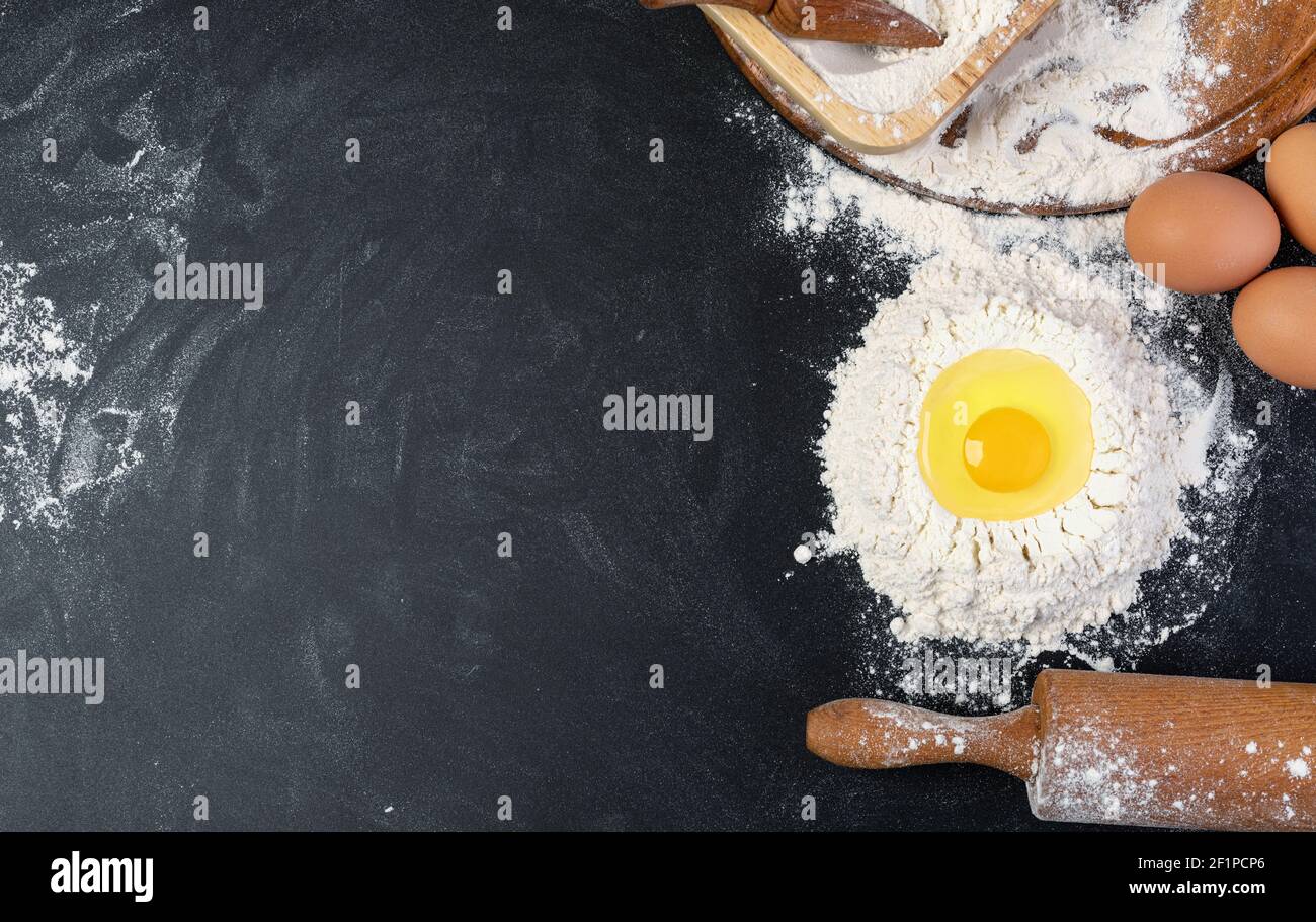 Rouleau à pâte et la farine blanche sur fond sombre Banque D'Images