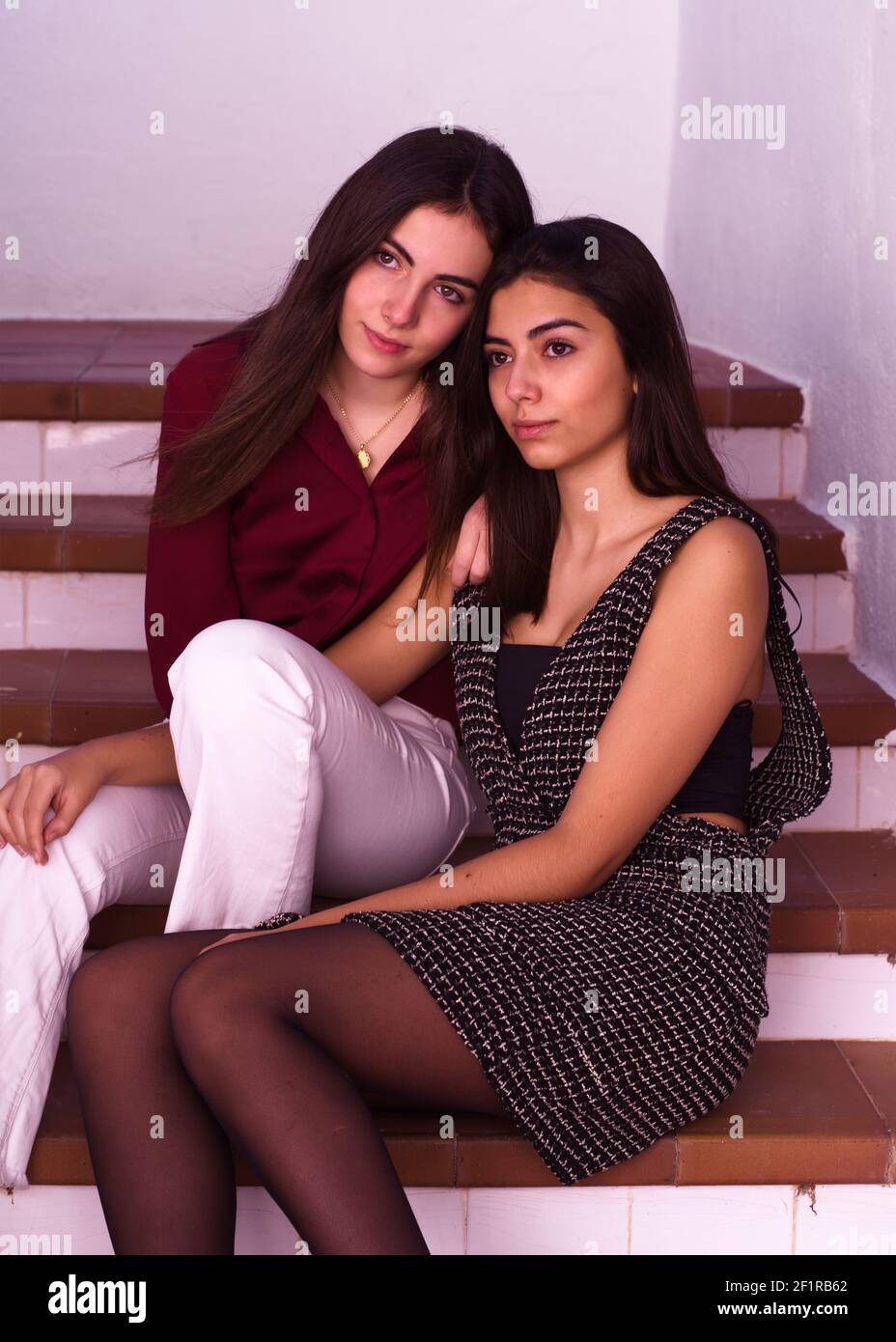 Deux jolies sœurs adolescentes assises près l'une de l'autre sur un escalier Banque D'Images
