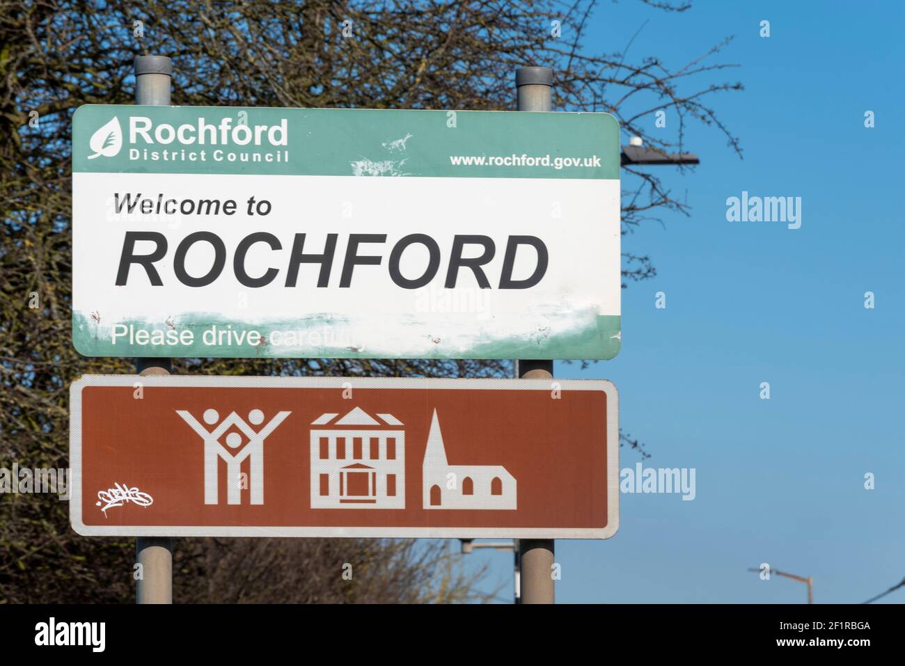 Bienvenue au panneau de Rochford, avec panneau marron avec les attractions locales. Symboles pour parc de campagne, maison d'architecture, d'intérêt historique, église. Décoloré Banque D'Images