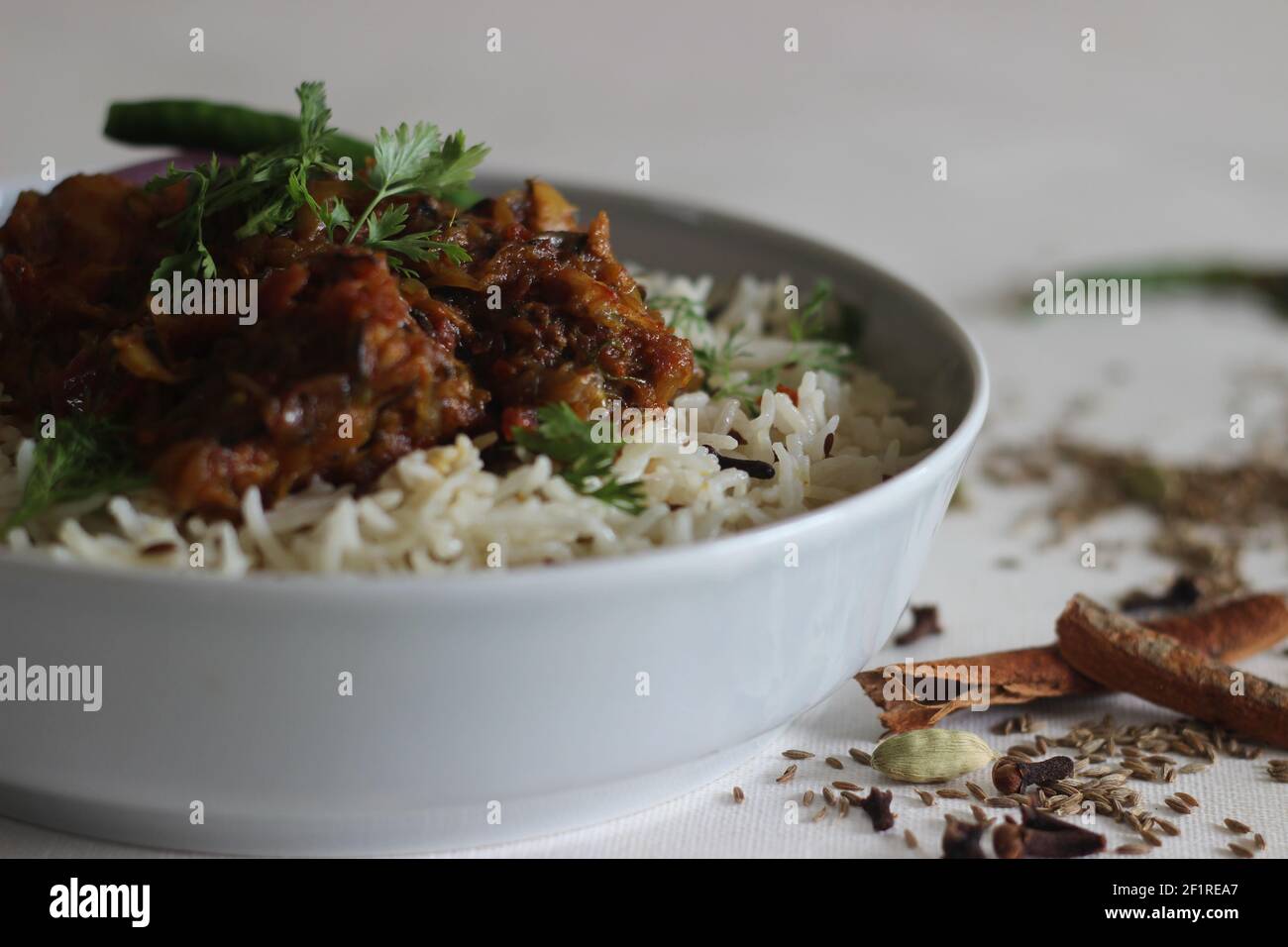 Riz Jeera et poulet rôti à sec. Une préparation de riz simple et savoureuse en une casserole avec des ingrédients de base. Prise sur fond blanc Banque D'Images