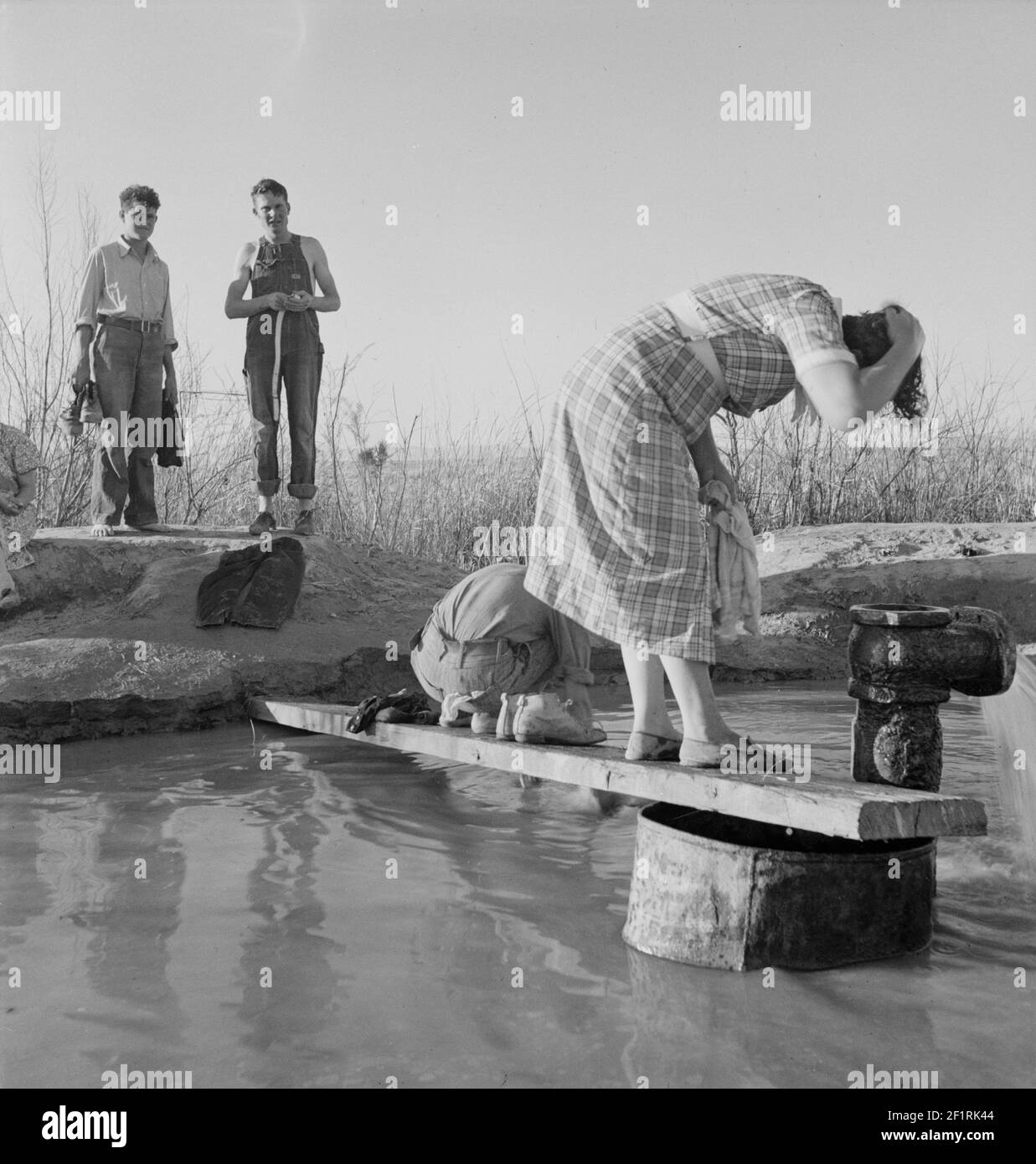 Les travailleurs migrants de l'Oklahoma se lavant dans une source chaude dans le désert. Imperial Valley, Californie - Photographie de Dorothea Lange Banque D'Images