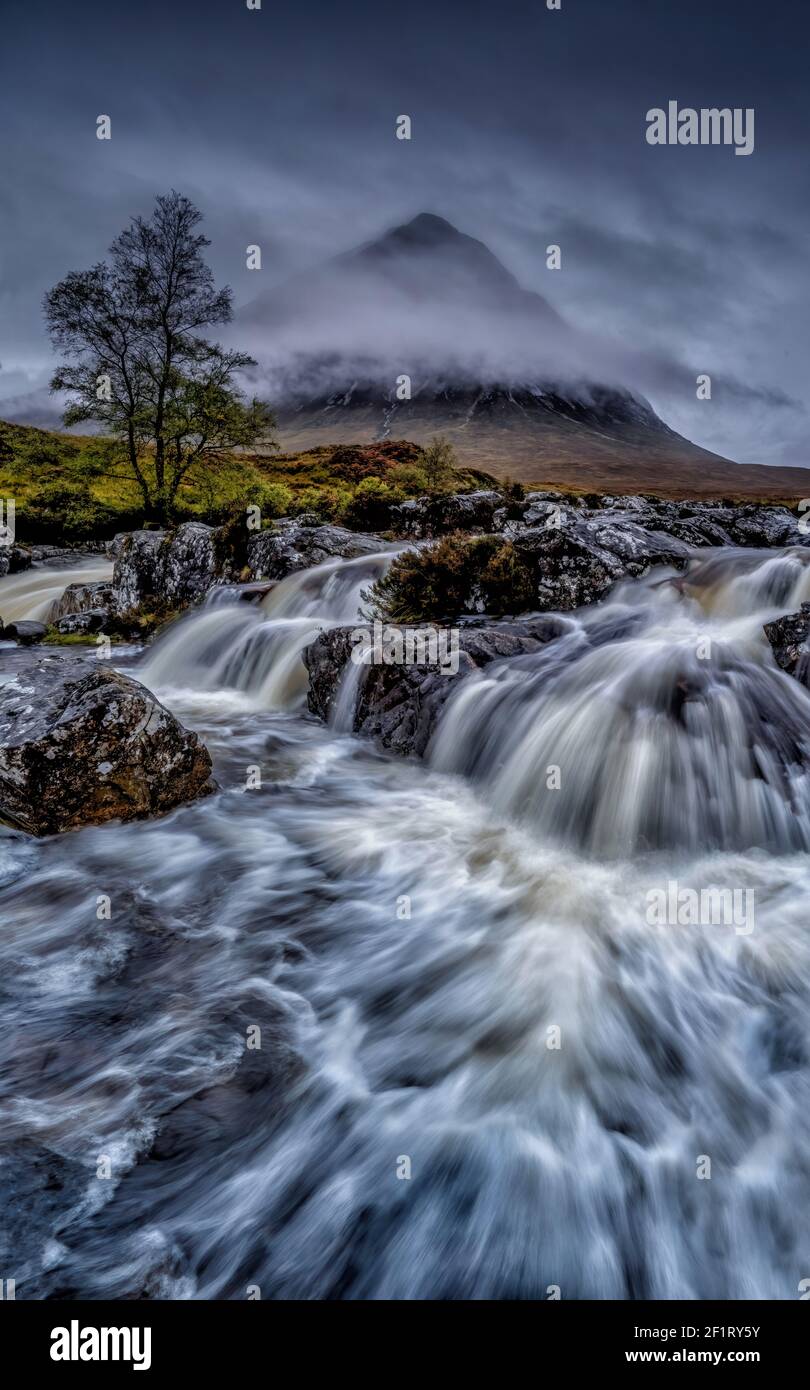 Cascade spectaculaire à Glencoe en Écosse. Glen Etive dans les Highlands écossais photographié lors d'une journée de tempête avec de lourds nuages bas Ecosse Royaume-Uni Banque D'Images