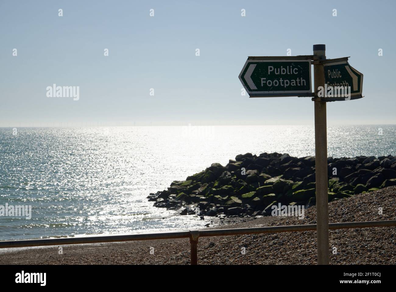 Panneau de sentier public le long d'une plage dans le sud de l'Angleterre. Mer, plage, horizon et rochers en arrière-plan. Banque D'Images