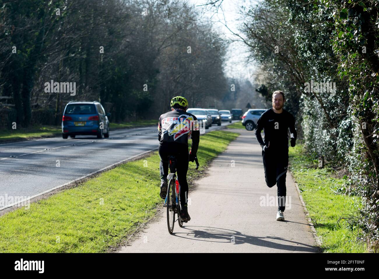 Cycliste et coureur sur un double sentier de cyclisme/marche pendant le verrouillage Covid-19, Warwick, Royaume-Uni. Mars 2021. Banque D'Images