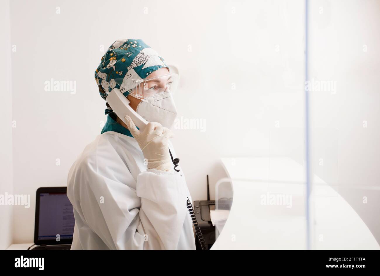 infirmière avec équipement de protection personnel et téléphone en mains, réception à l'hôpital dentaire Banque D'Images