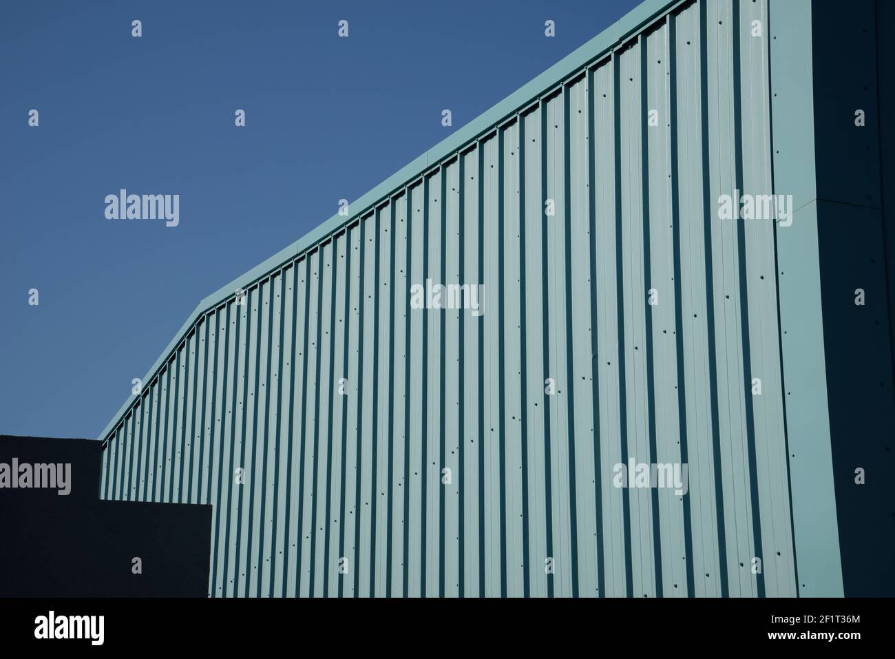Détails architecturaux. Côté métallique fabriqué d'un entrepôt industriel. Formes abstraites. Ciel bleu. Banque D'Images