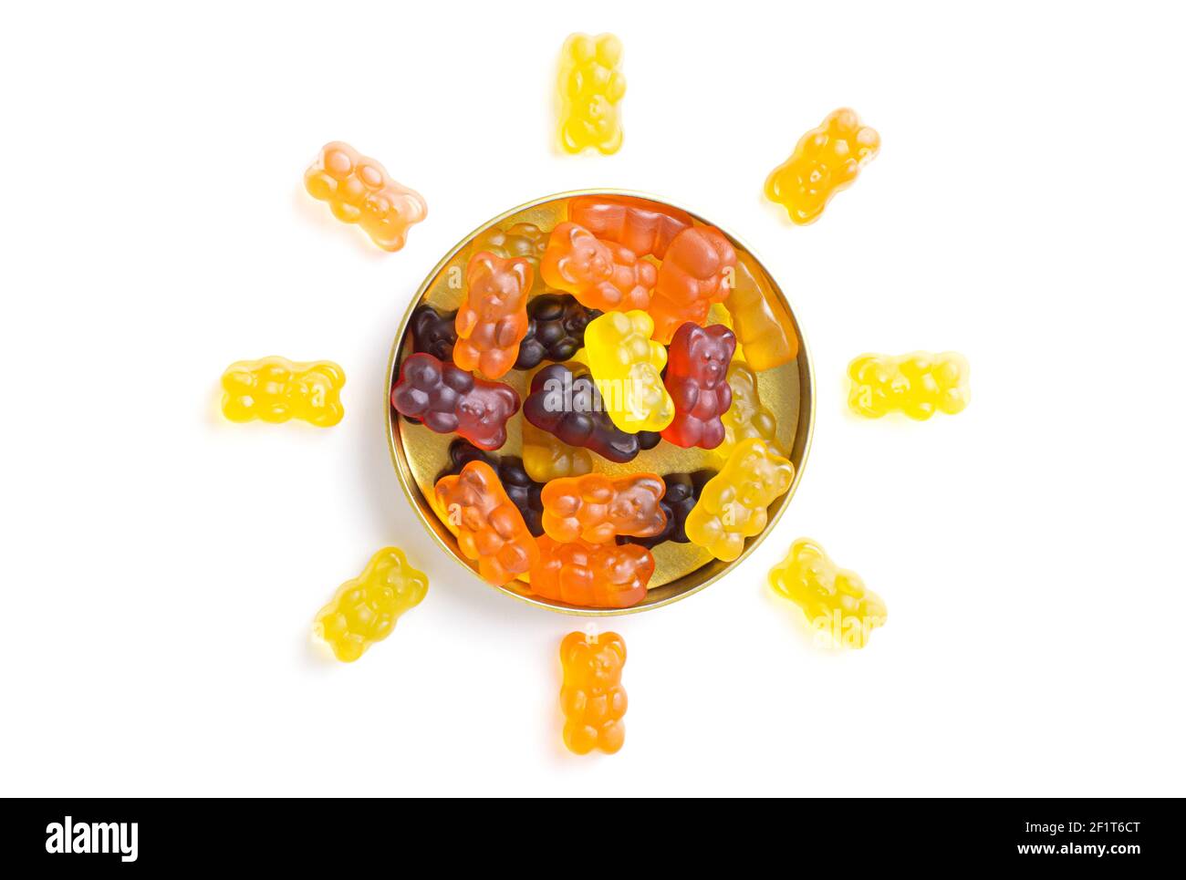 Des ours délicieux disposés en forme de soleil autour d'une boîte de bonbons sur fond blanc. Banque D'Images